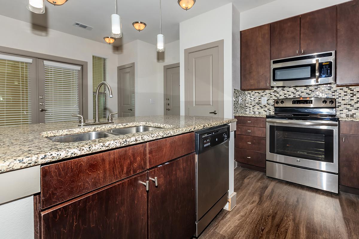 a large kitchen with stainless steel appliances and wooden cabinets