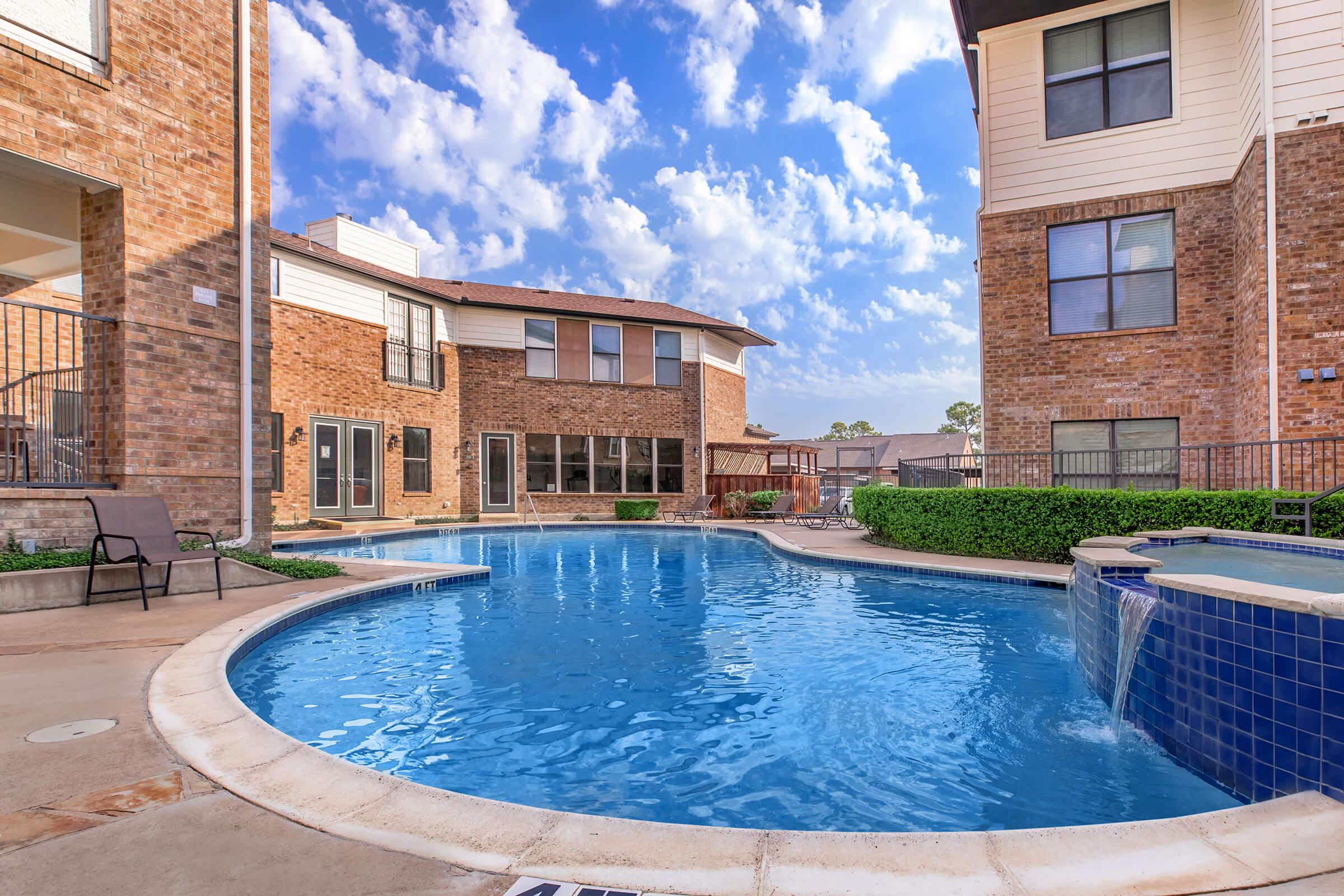 a man in a pool of water in front of a brick building