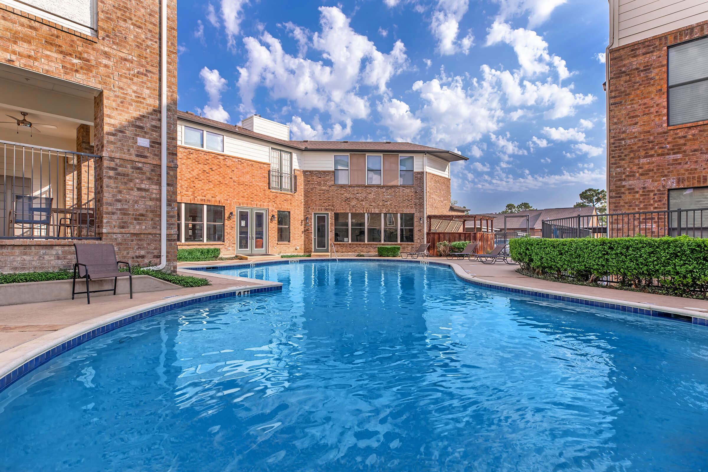 a large brick building with a pool of water