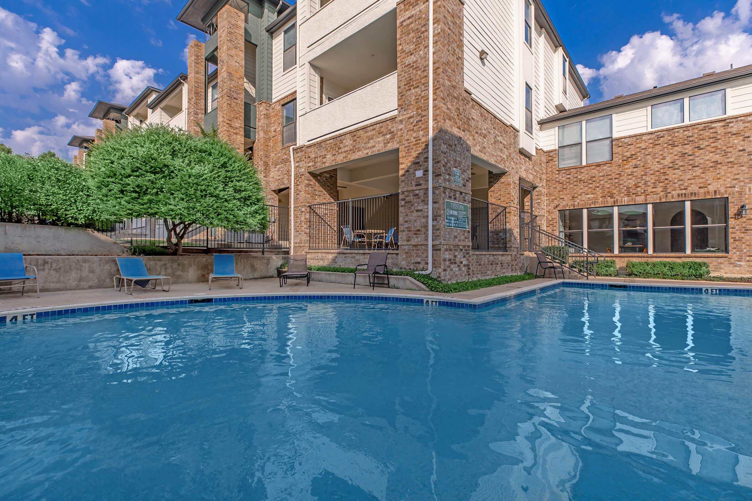 a large brick building with a pool of water