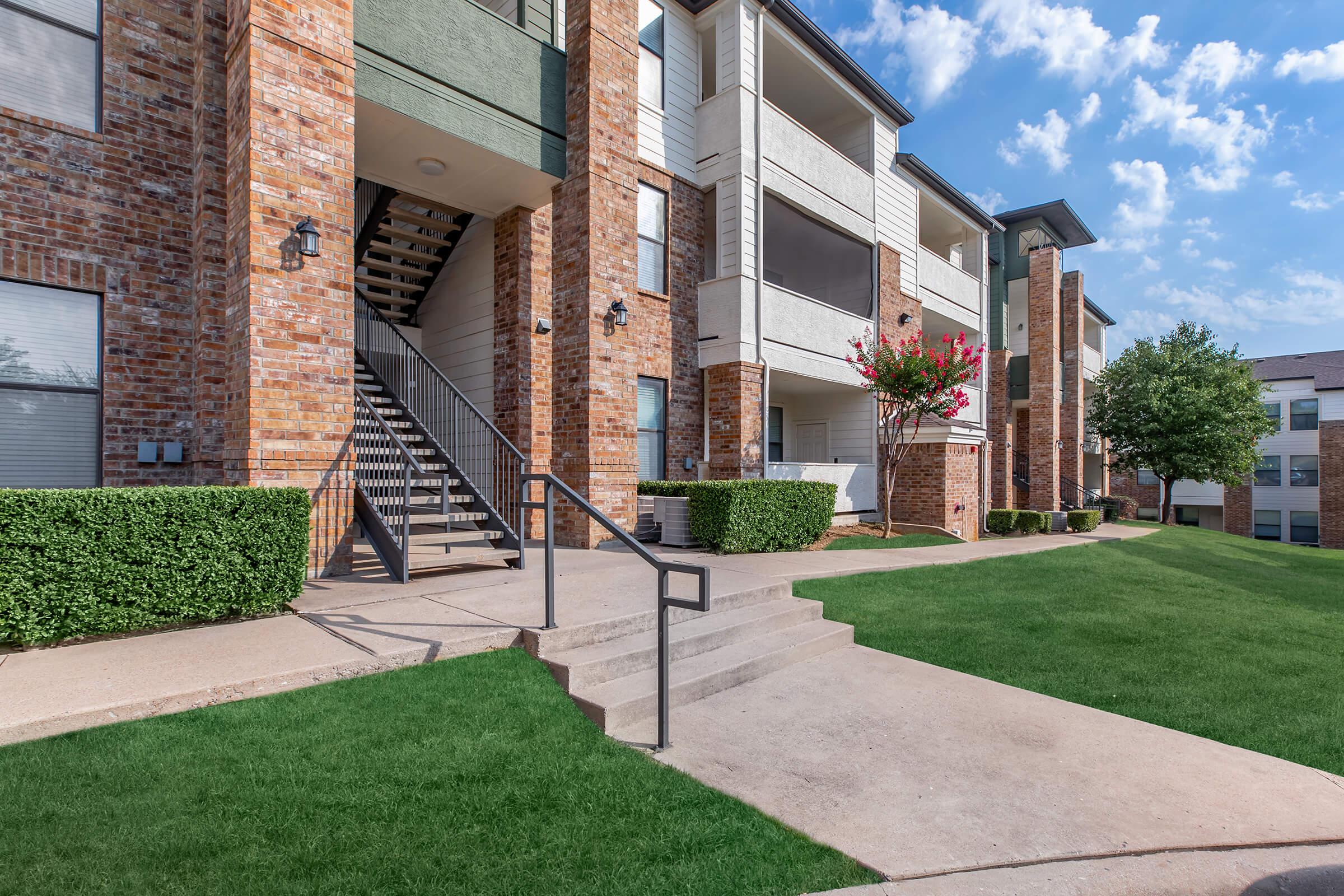 a large lawn in front of a brick building