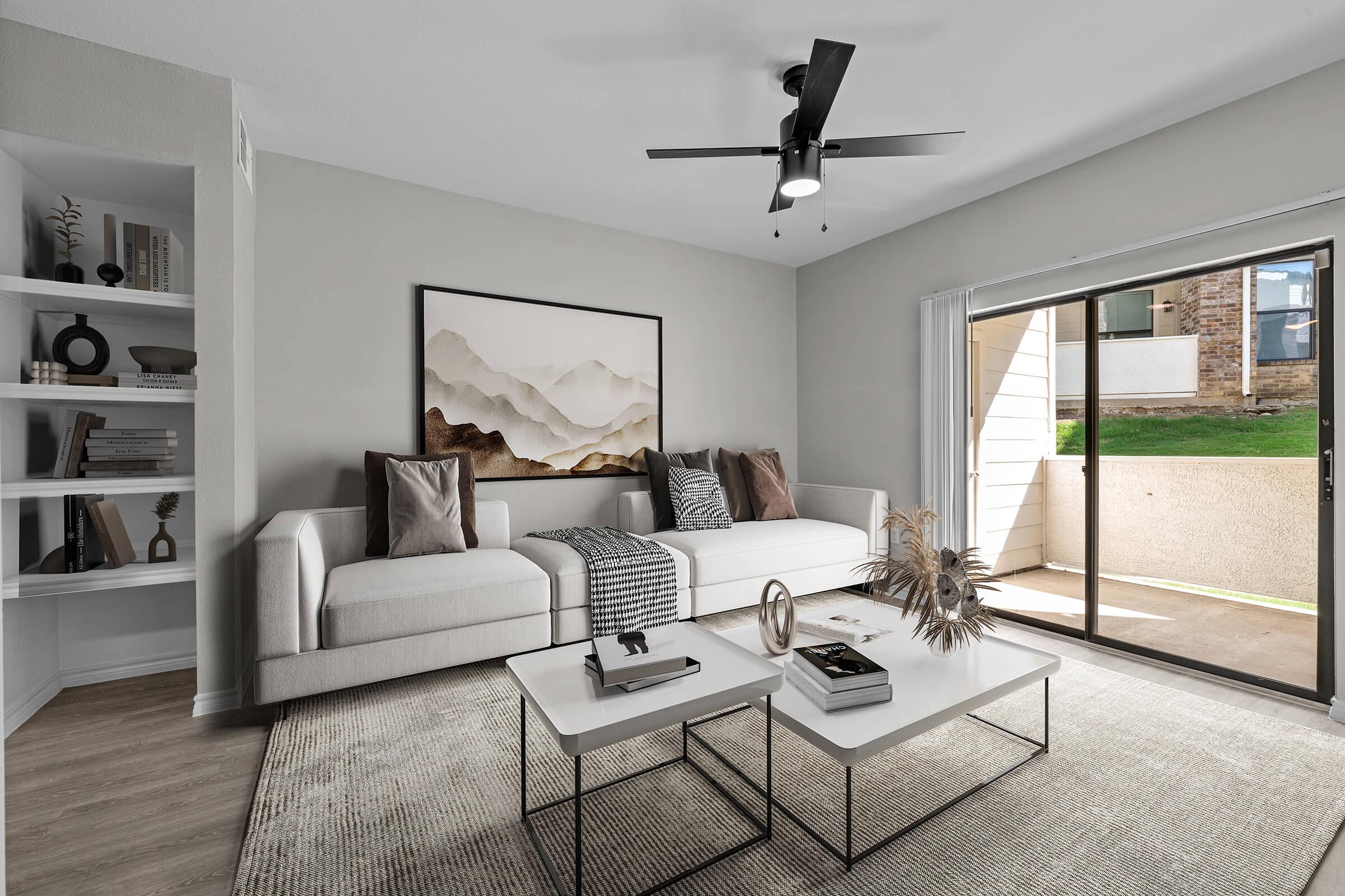 a living room filled with furniture and a large window