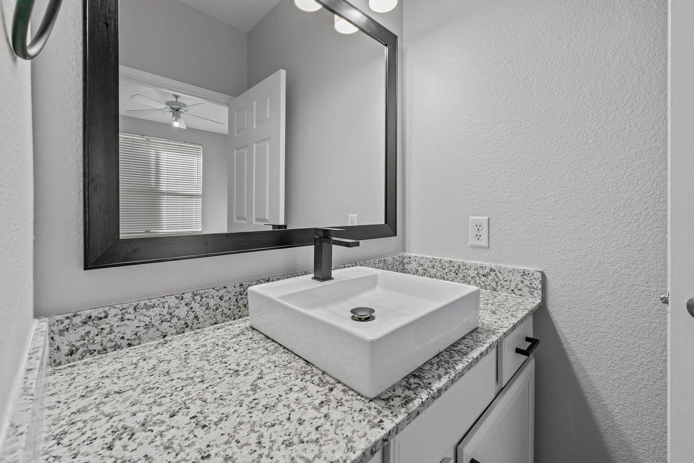 a bedroom area with a sink and a mirror