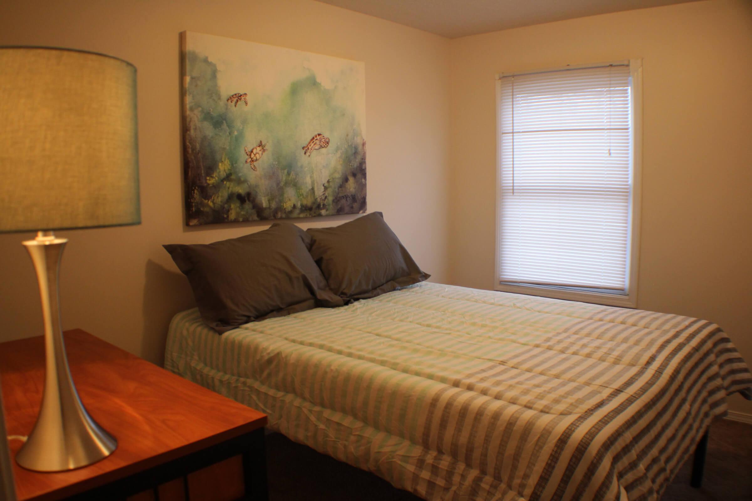 a bedroom with a bed and desk in a room