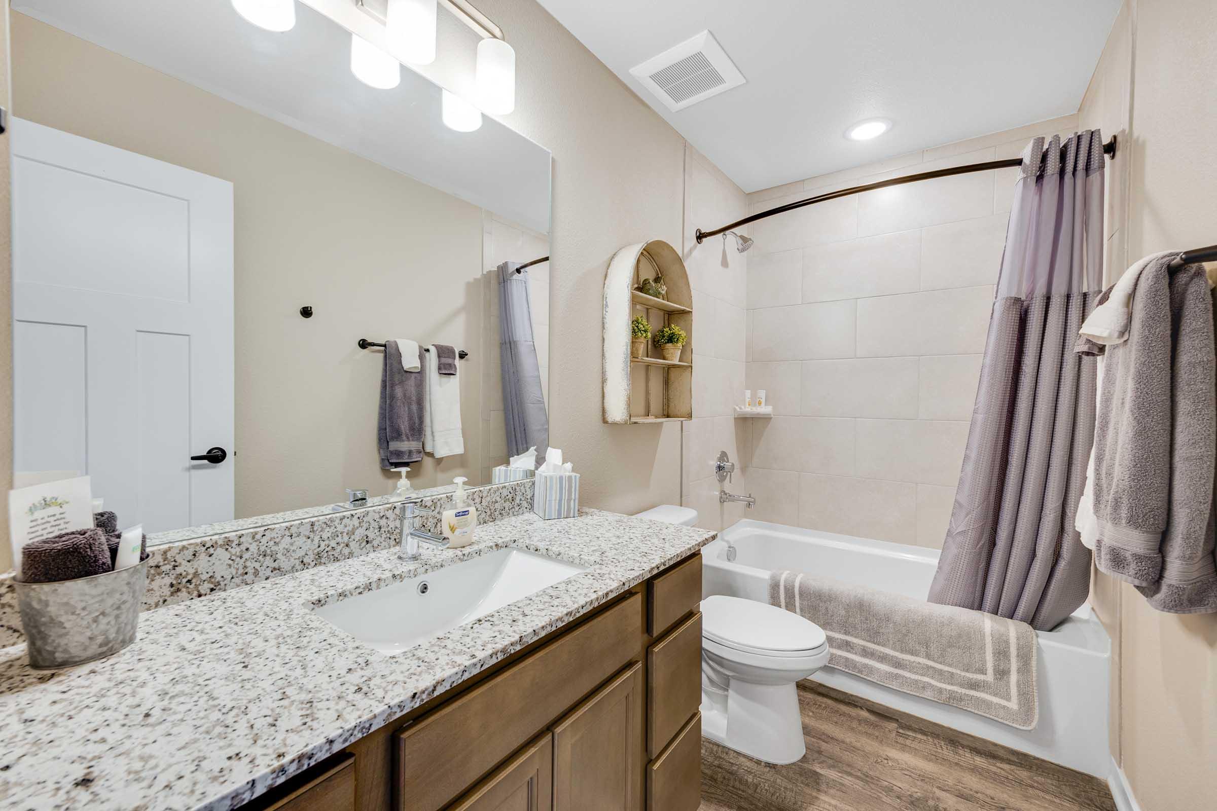 a bedroom with a large mirror next to a sink