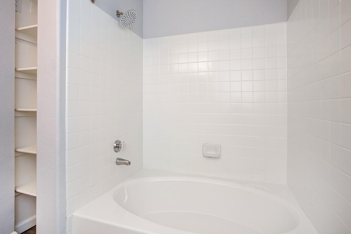 a white tub sitting next to a shower