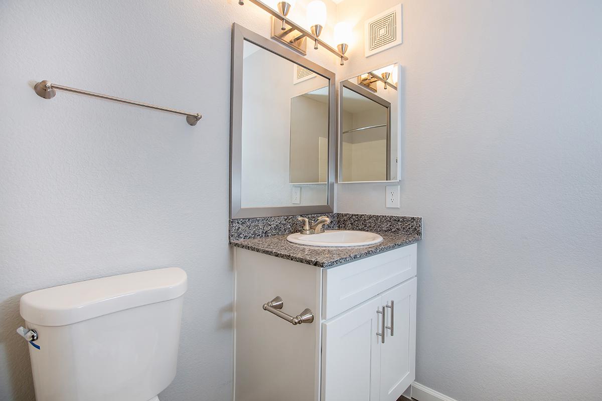 a white sink sitting under a mirror