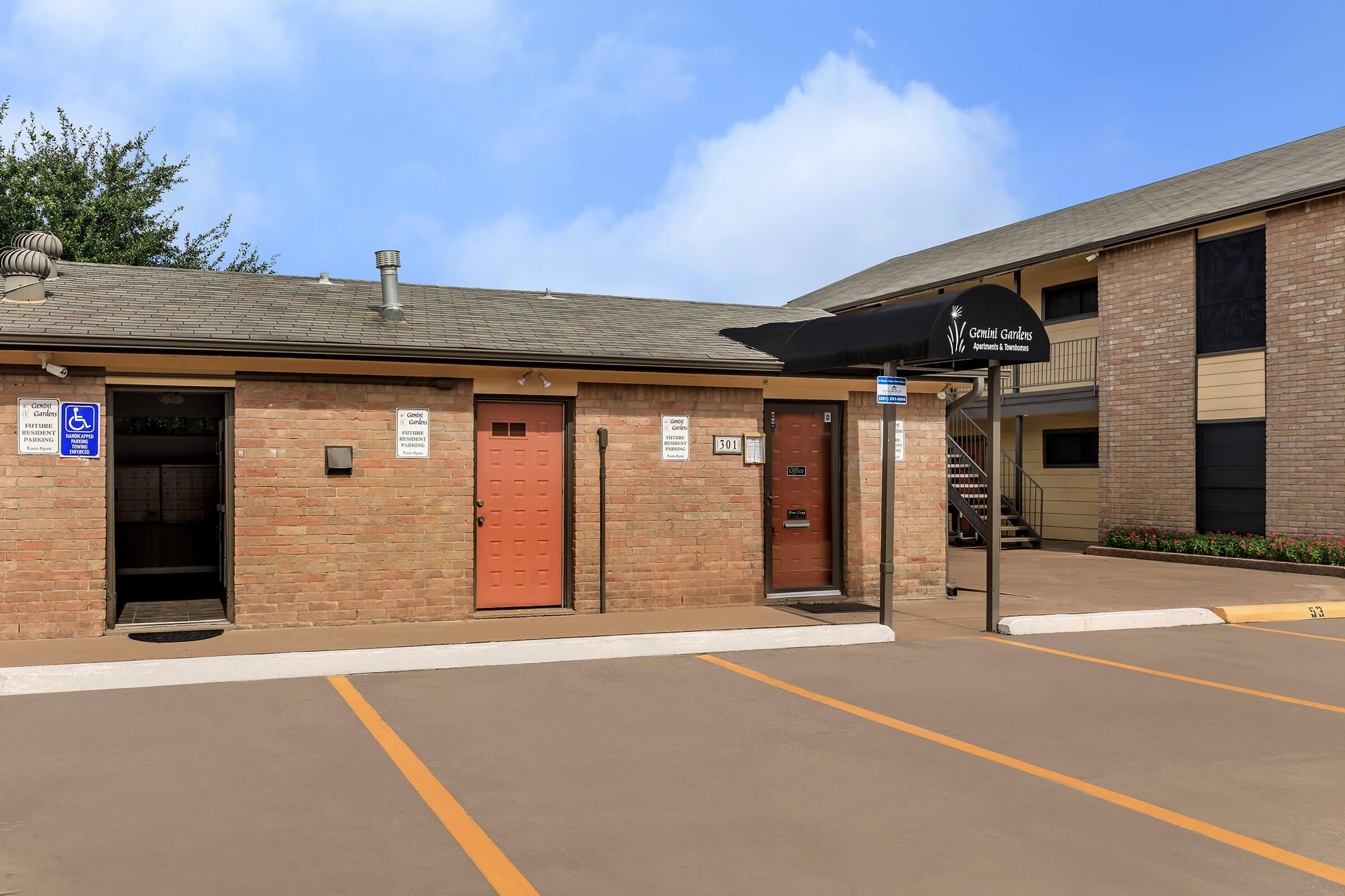 a large brick building with a clock on the side of a road