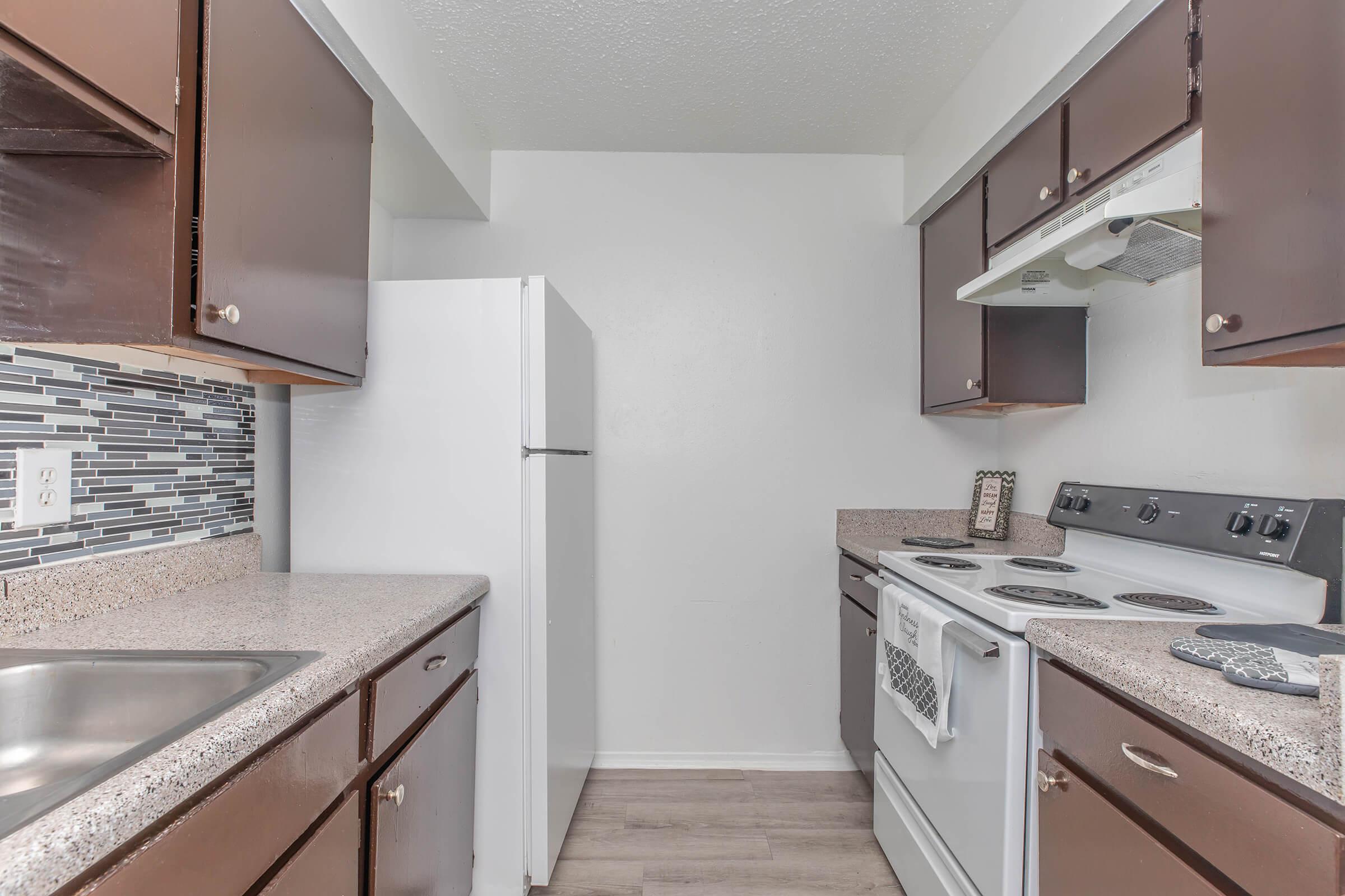 a kitchen with a stove a sink and a mirror