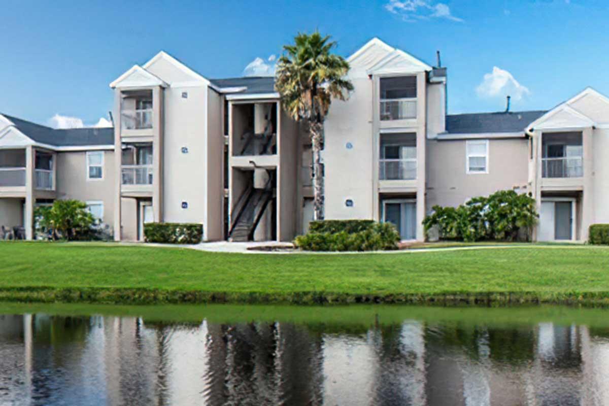 A modern apartment complex with a light exterior, featuring multiple units and a staircase.