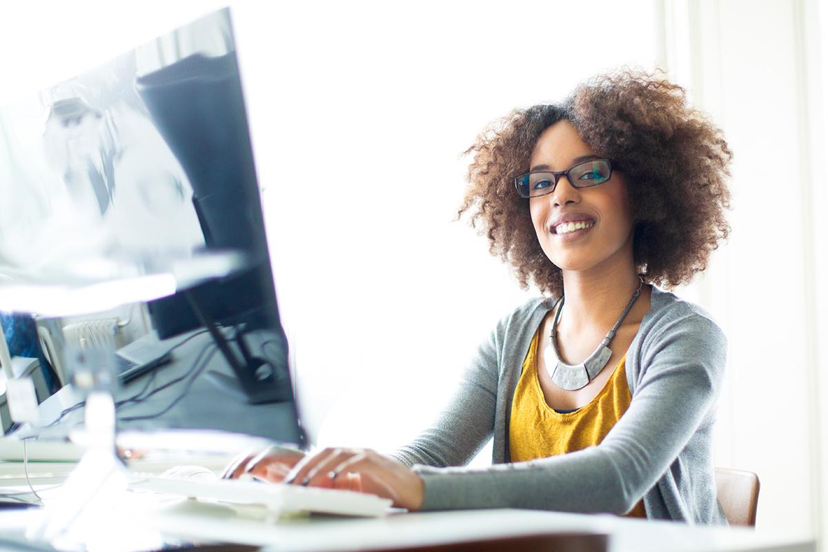 a woman wearing glasses and smiling at the camera