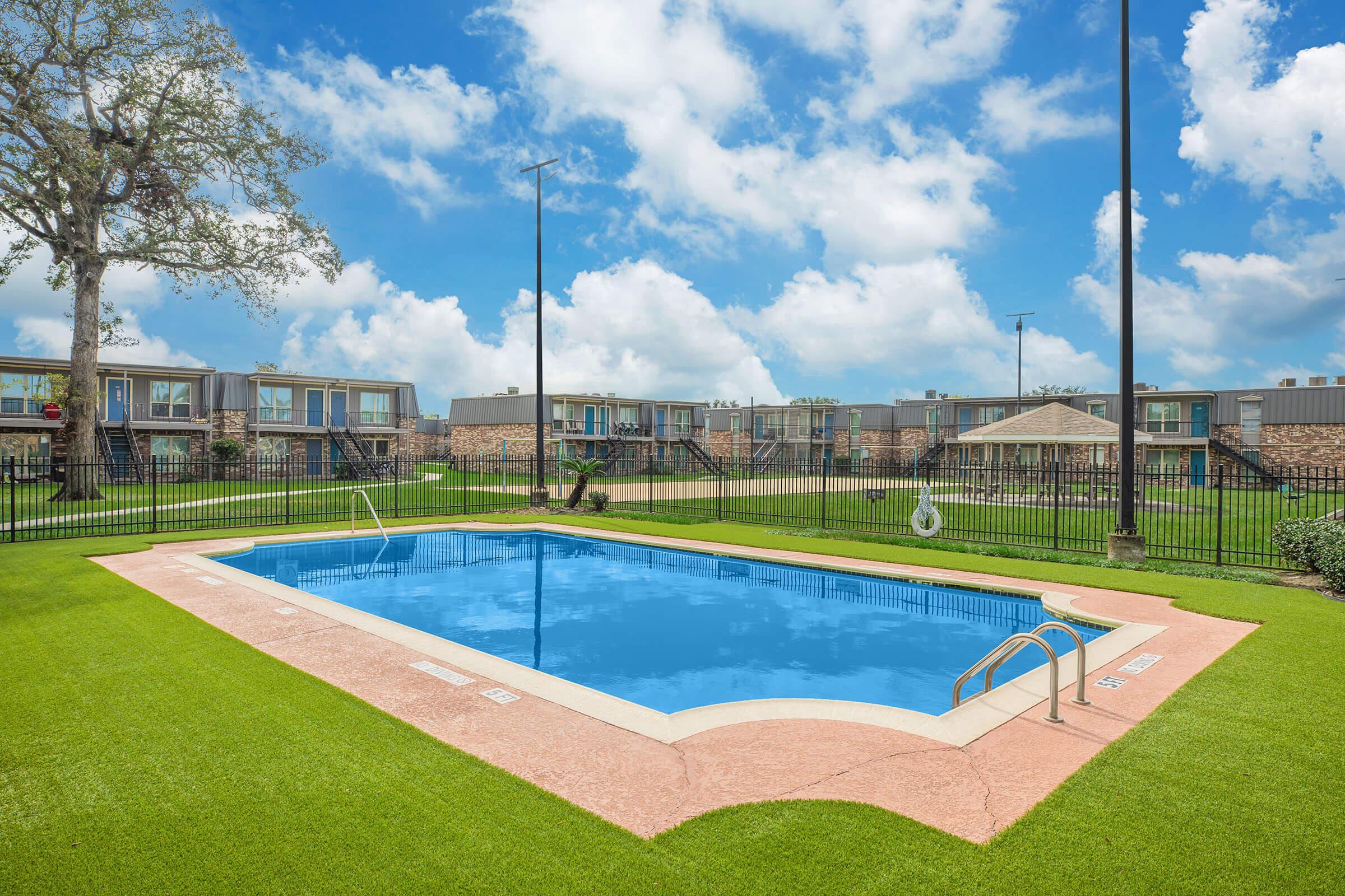 a large lawn in front of a pool