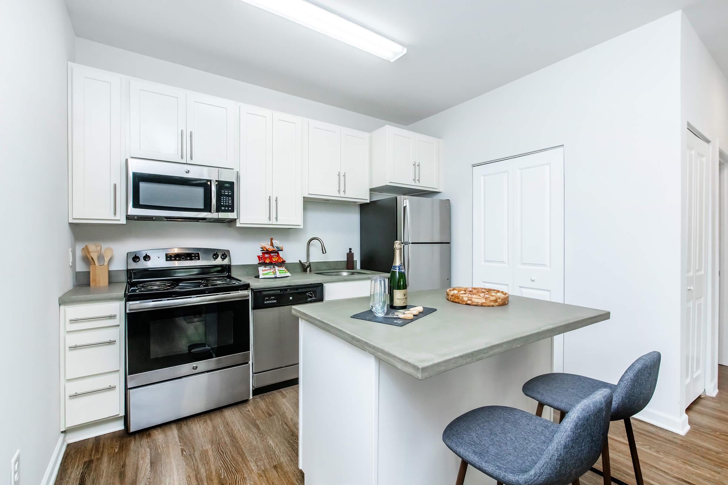 a kitchen with a stove refrigerator and table in a room