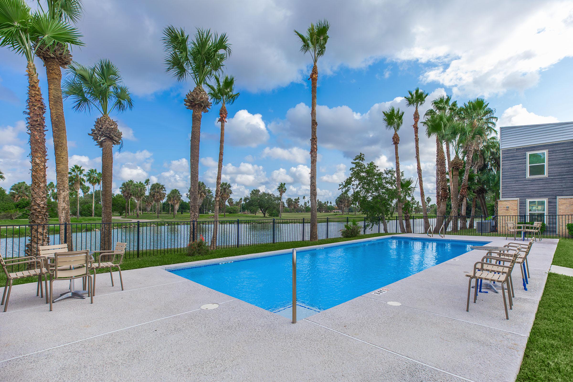 a group of lawn chairs sitting next to a pool of water