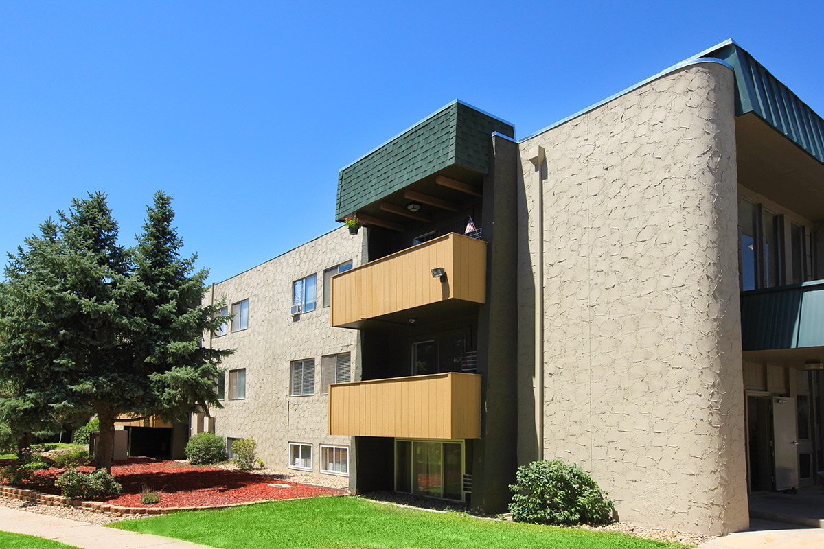 a large brick building with grass in front of a house