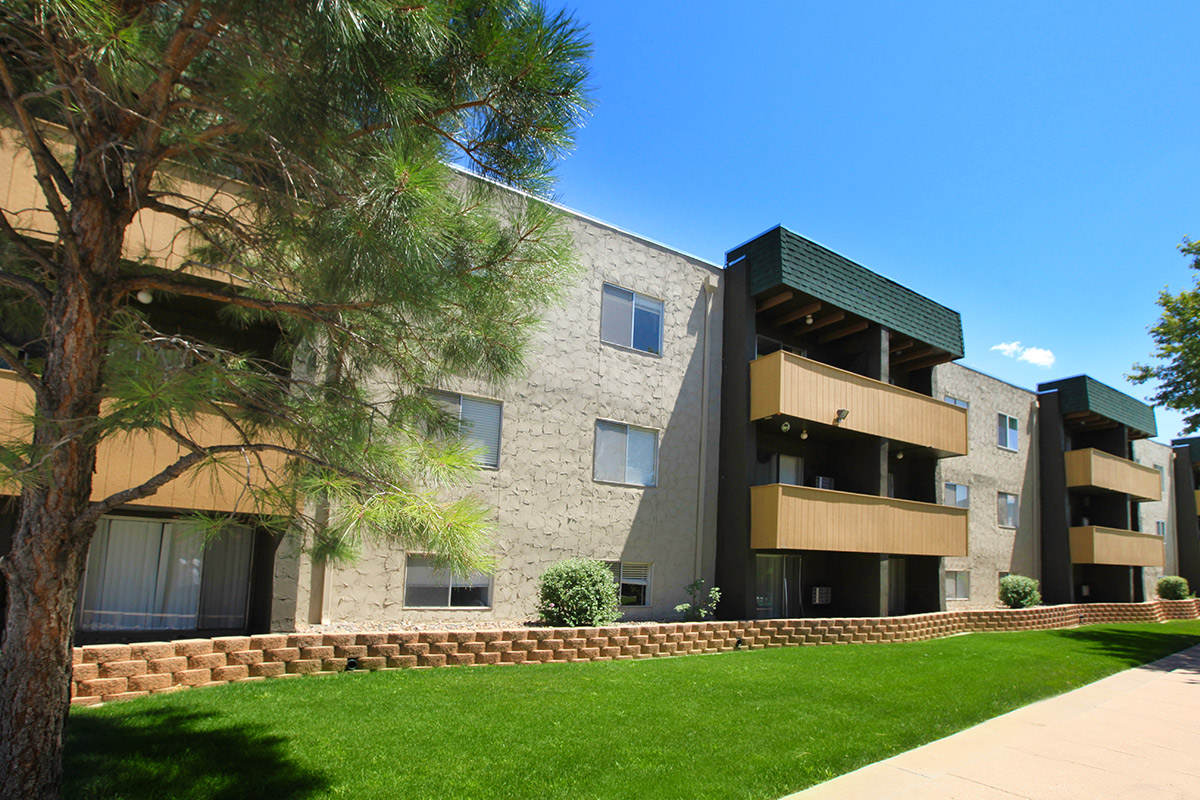 a large brick building with grass in front of a house