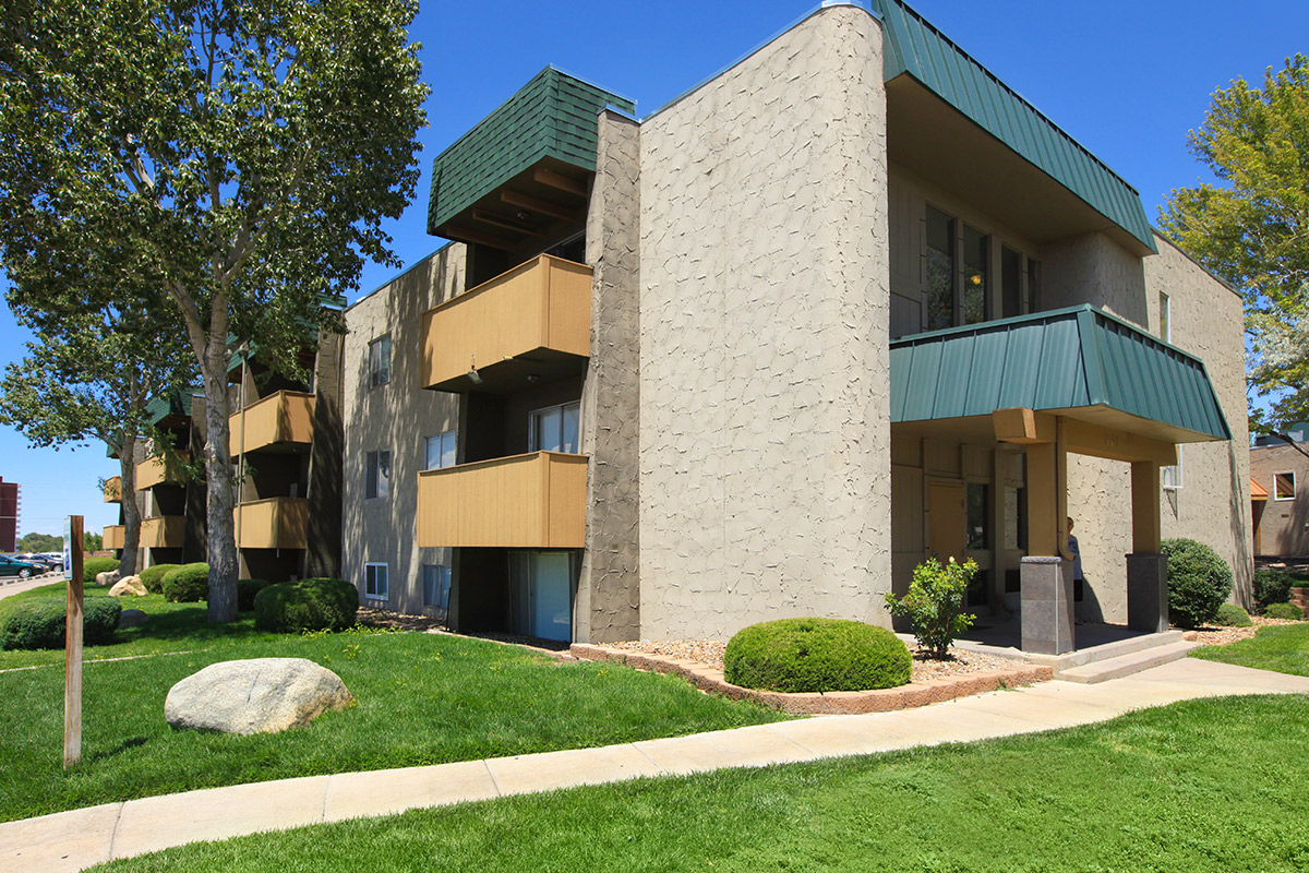 a house with a lawn in front of a brick building