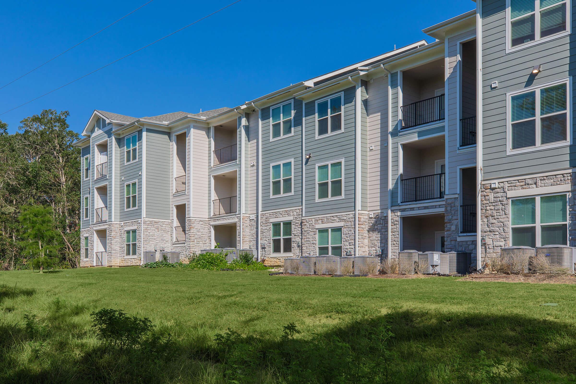 a large green field in front of a building