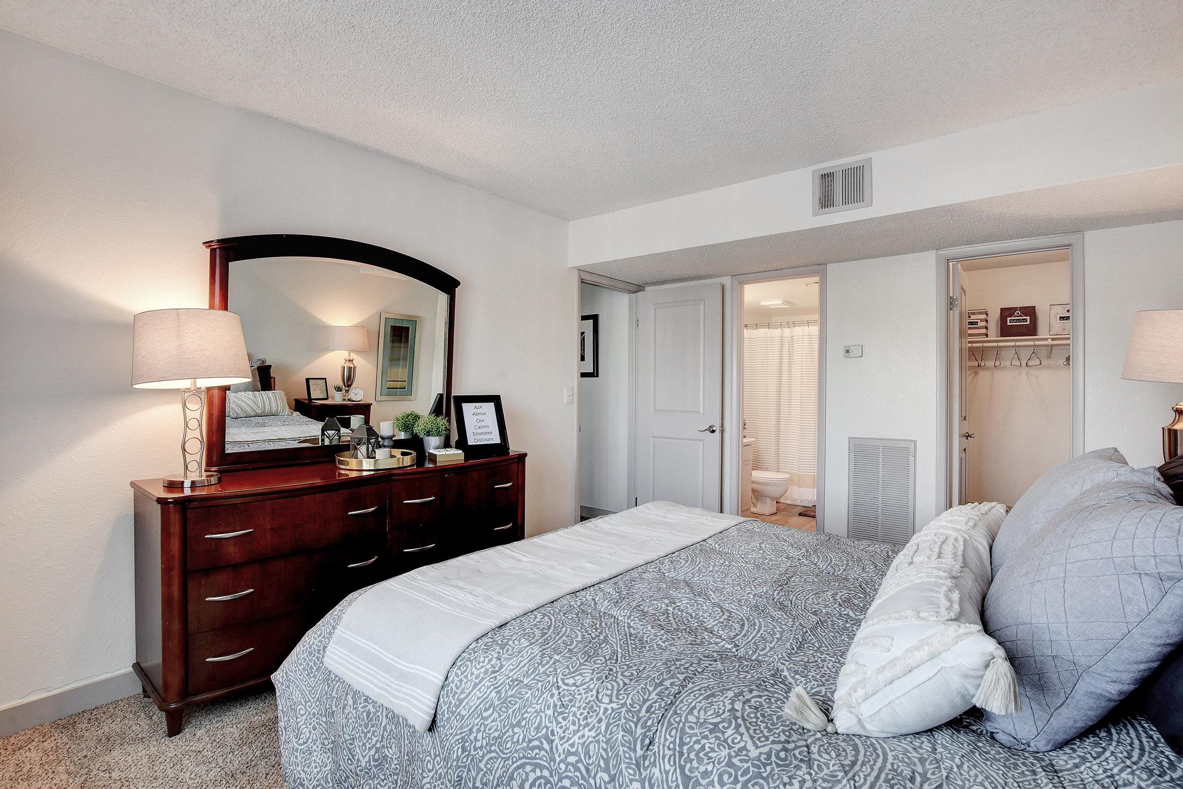 a bedroom with a bed and desk in a room