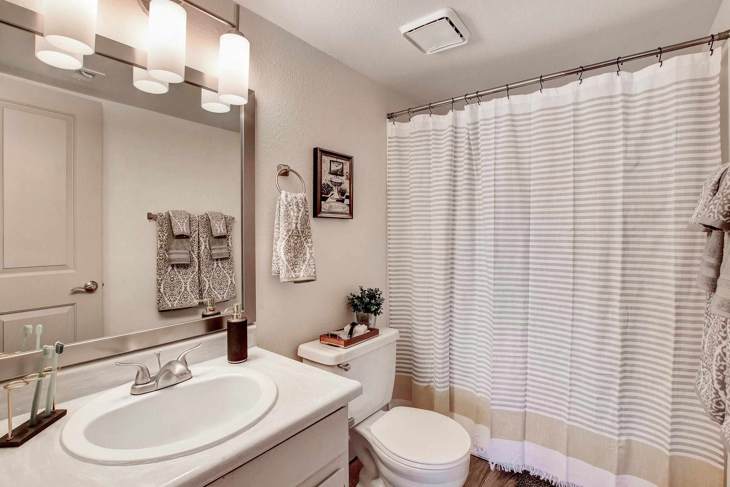 a white sink sitting under a mirror