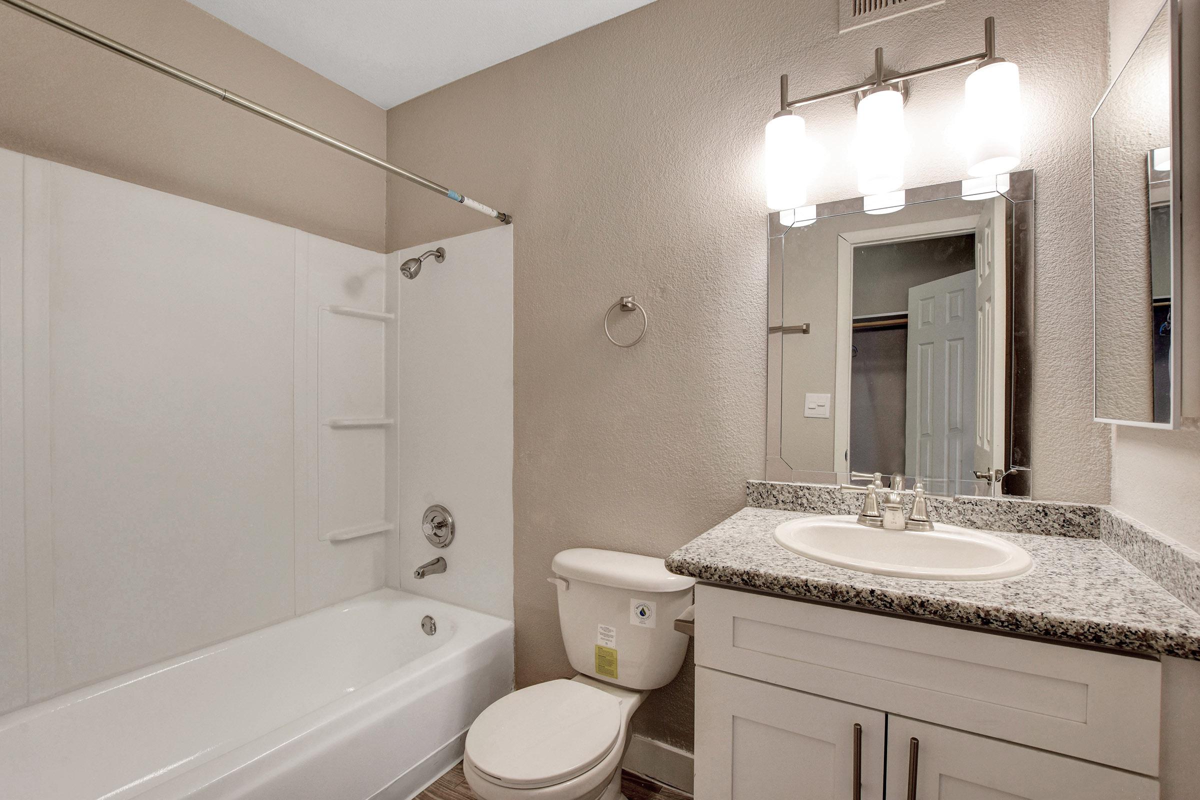 a white sink sitting under a mirror