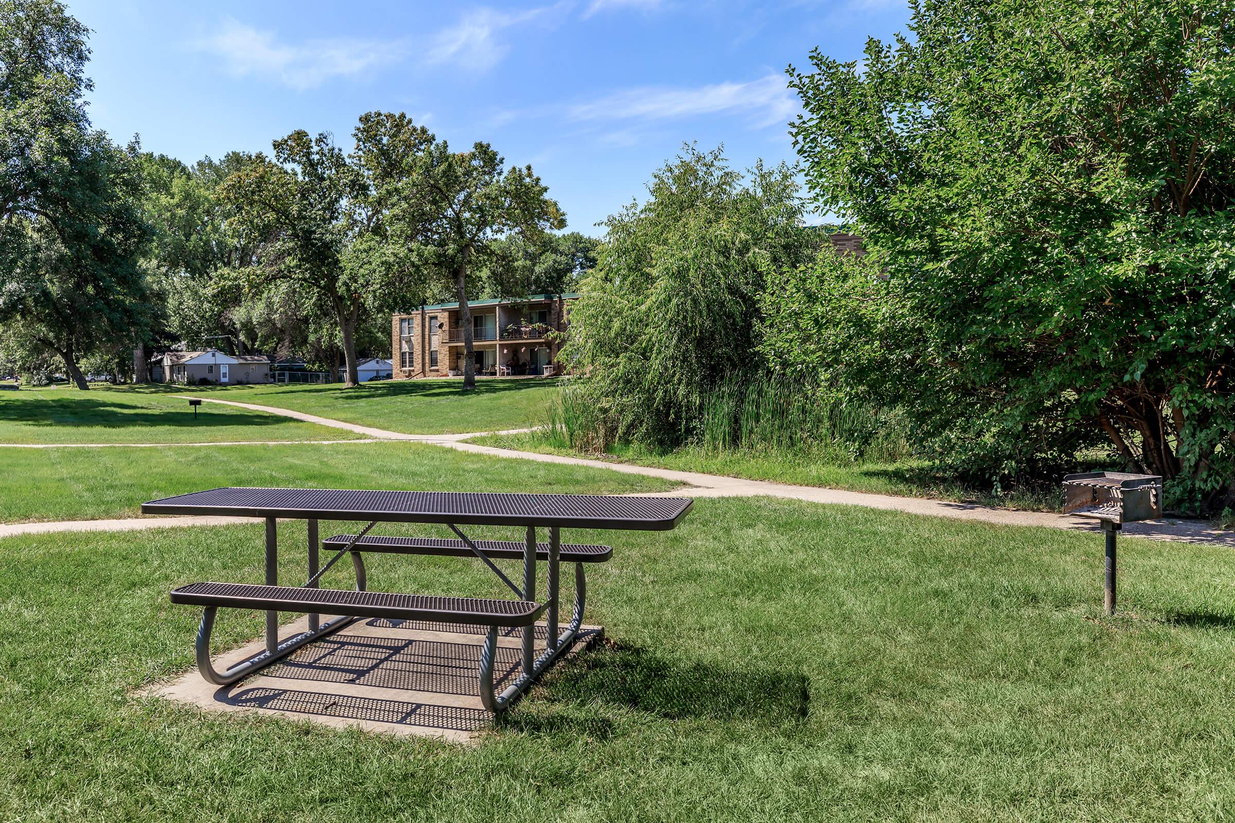 a wooden bench sitting on top of a lush green field