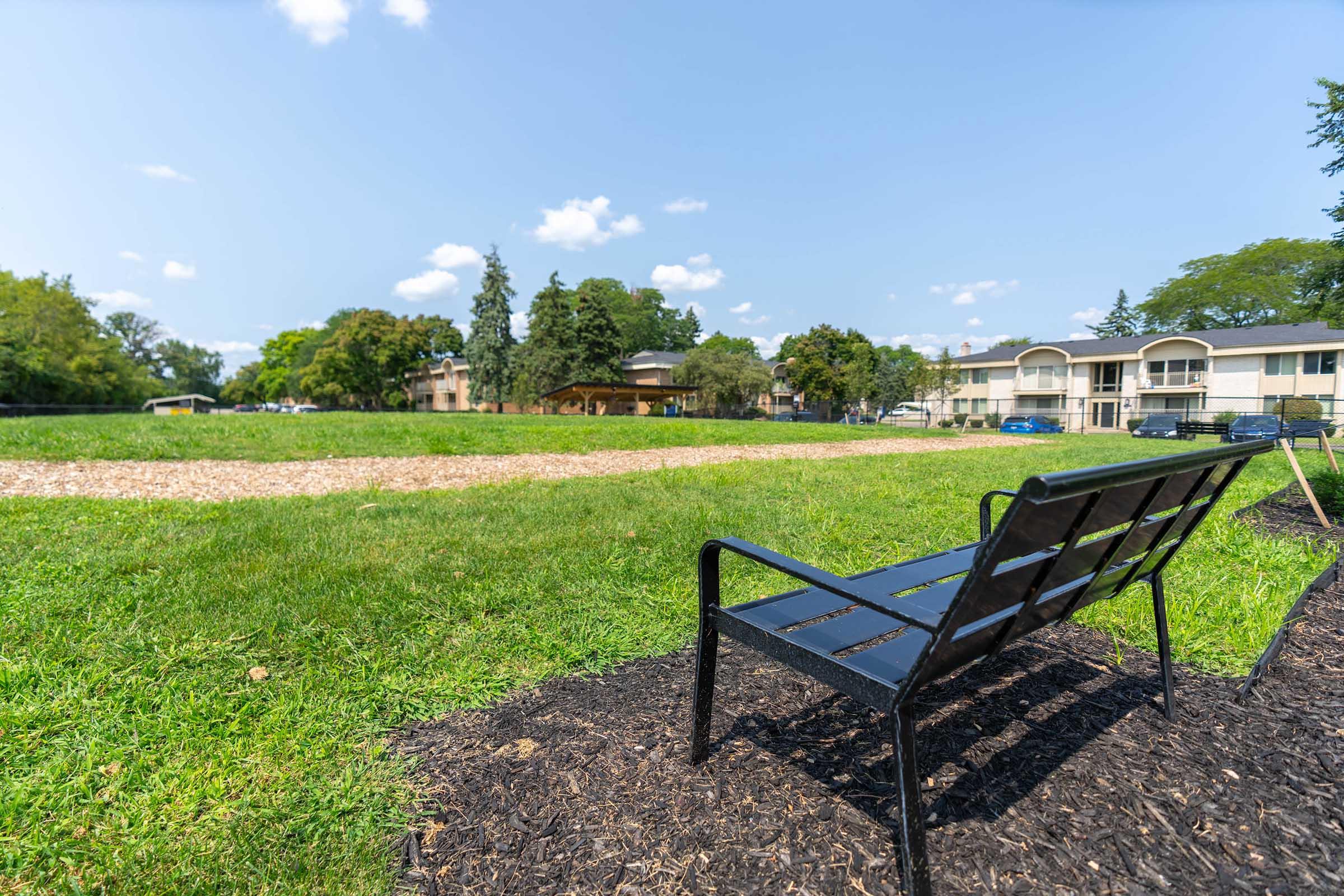 a couple of lawn chairs sitting on top of a grass covered field