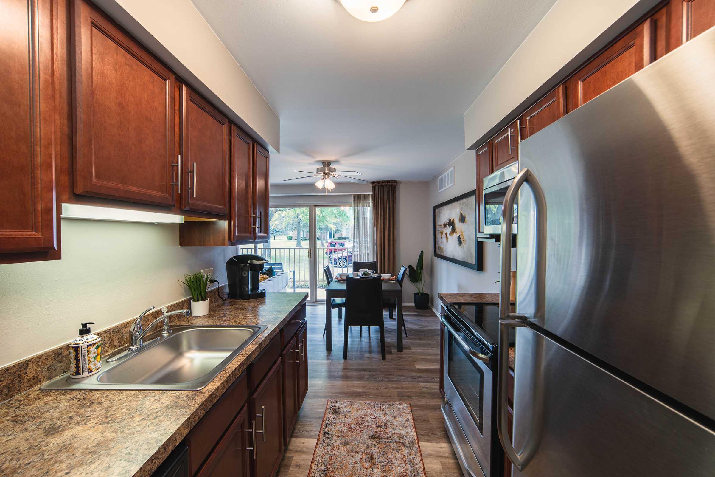 a large kitchen with stainless steel appliances and wooden cabinets