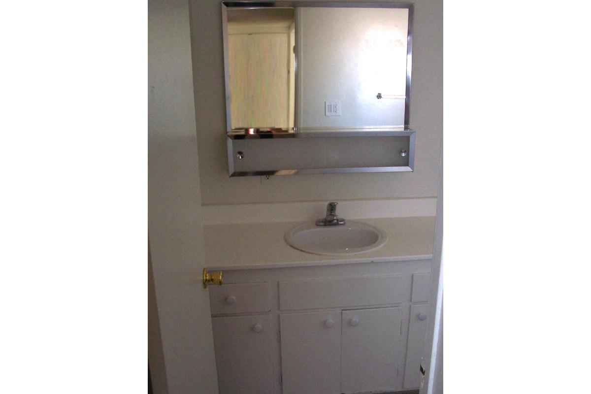 a white sink sitting under a mirror