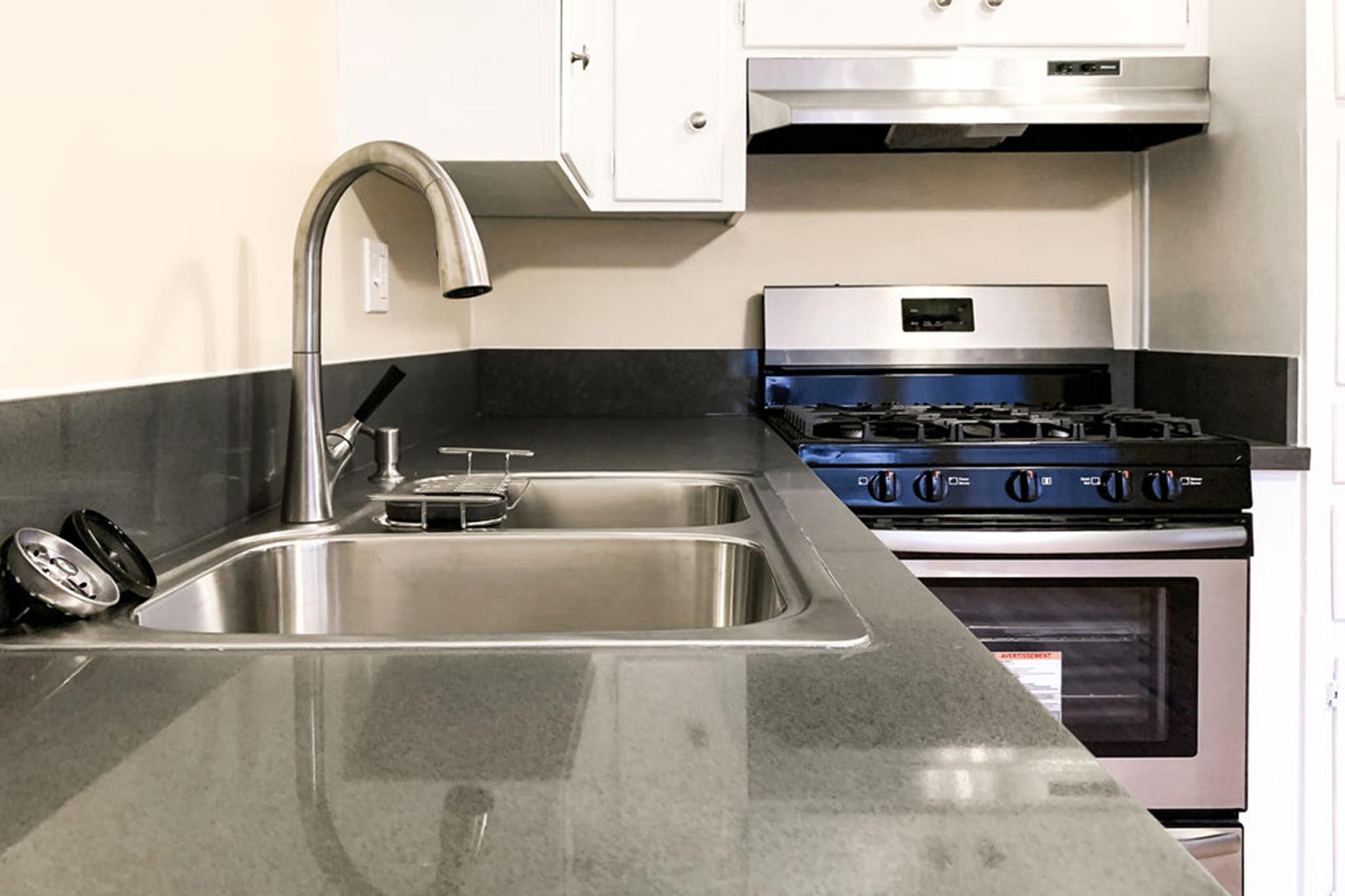 a stove top oven sitting inside of a kitchen with stainless steel appliances