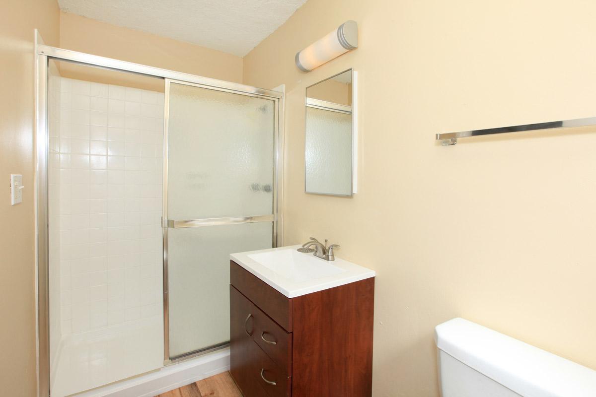 a white sink sitting next to a shower