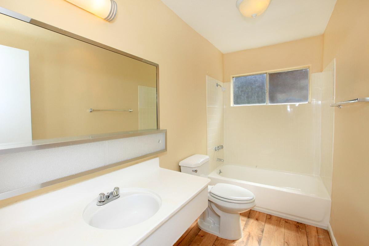 a white sink sitting under a mirror