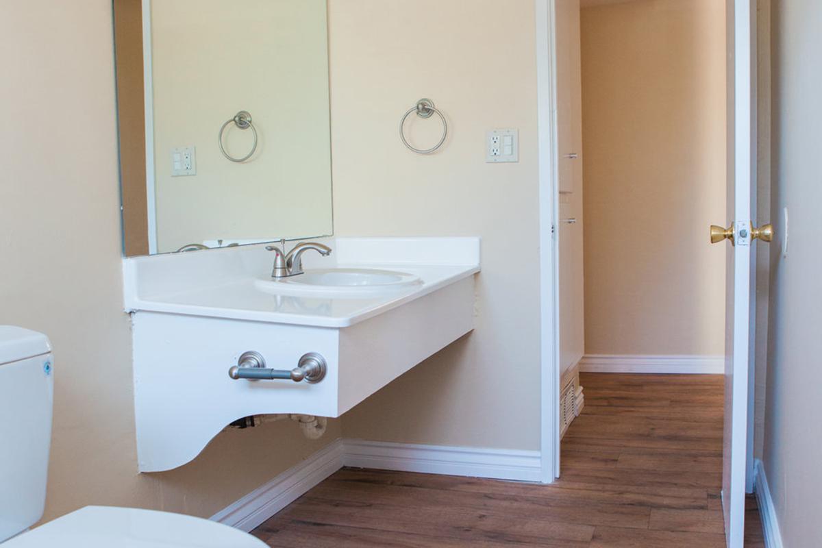 a white sink sitting under a mirror