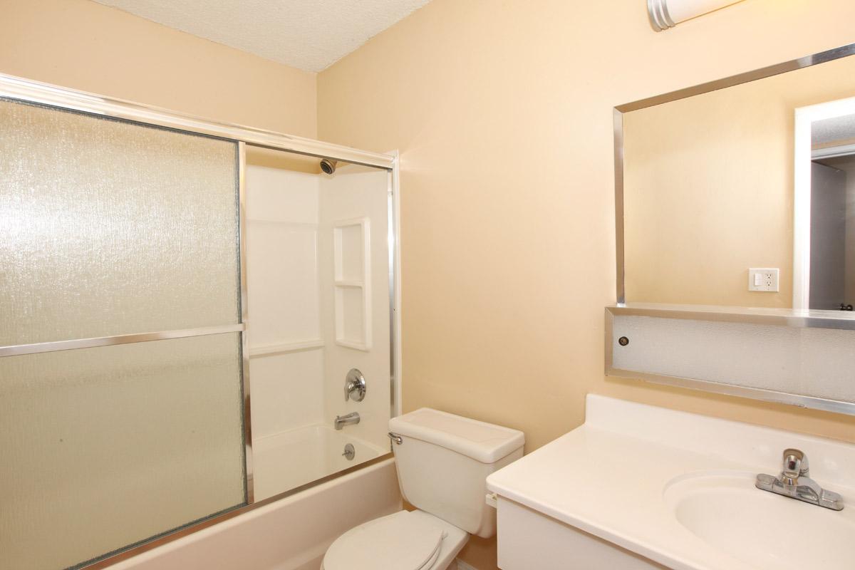 a white sink sitting under a mirror