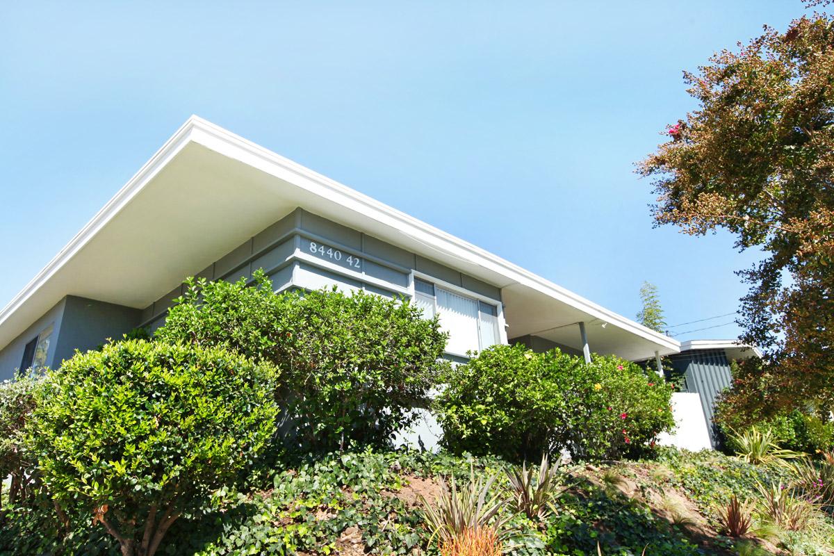 a house with bushes in front of a building