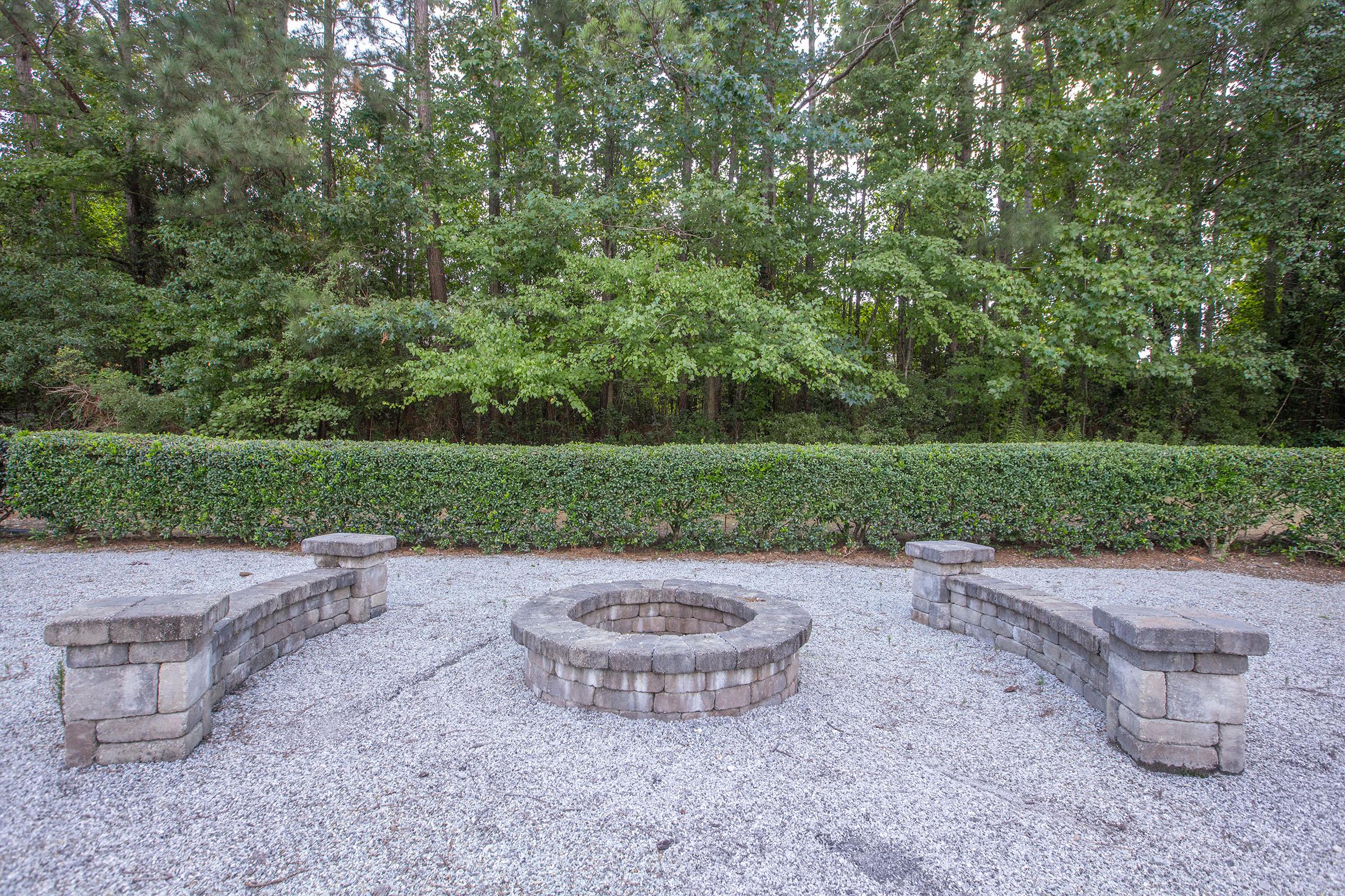 a statue of a cement bench sitting next to a stone wall