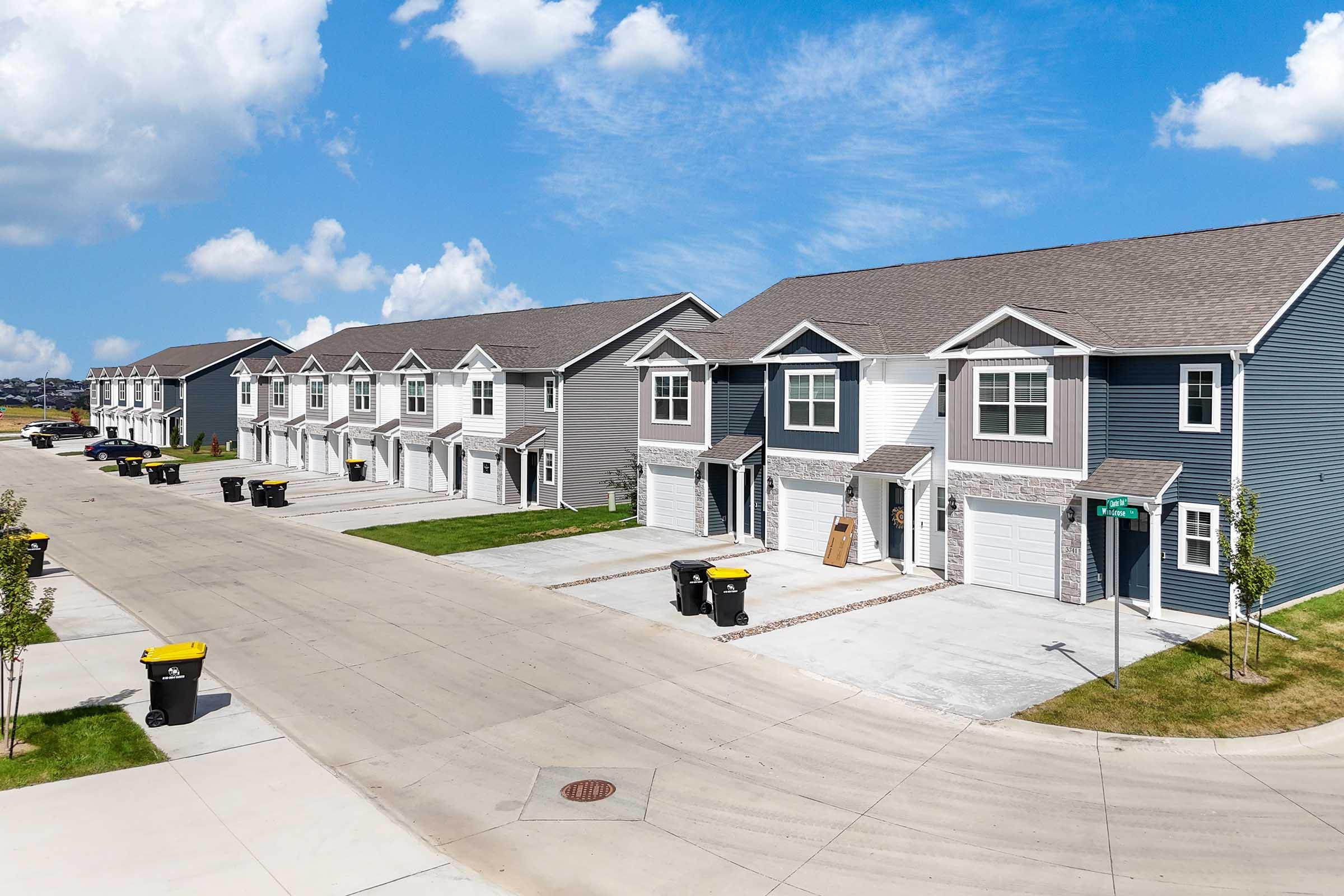 Modern row of new construction townhomes with attached garages at Painted Woods Villas in Waukee, IA.