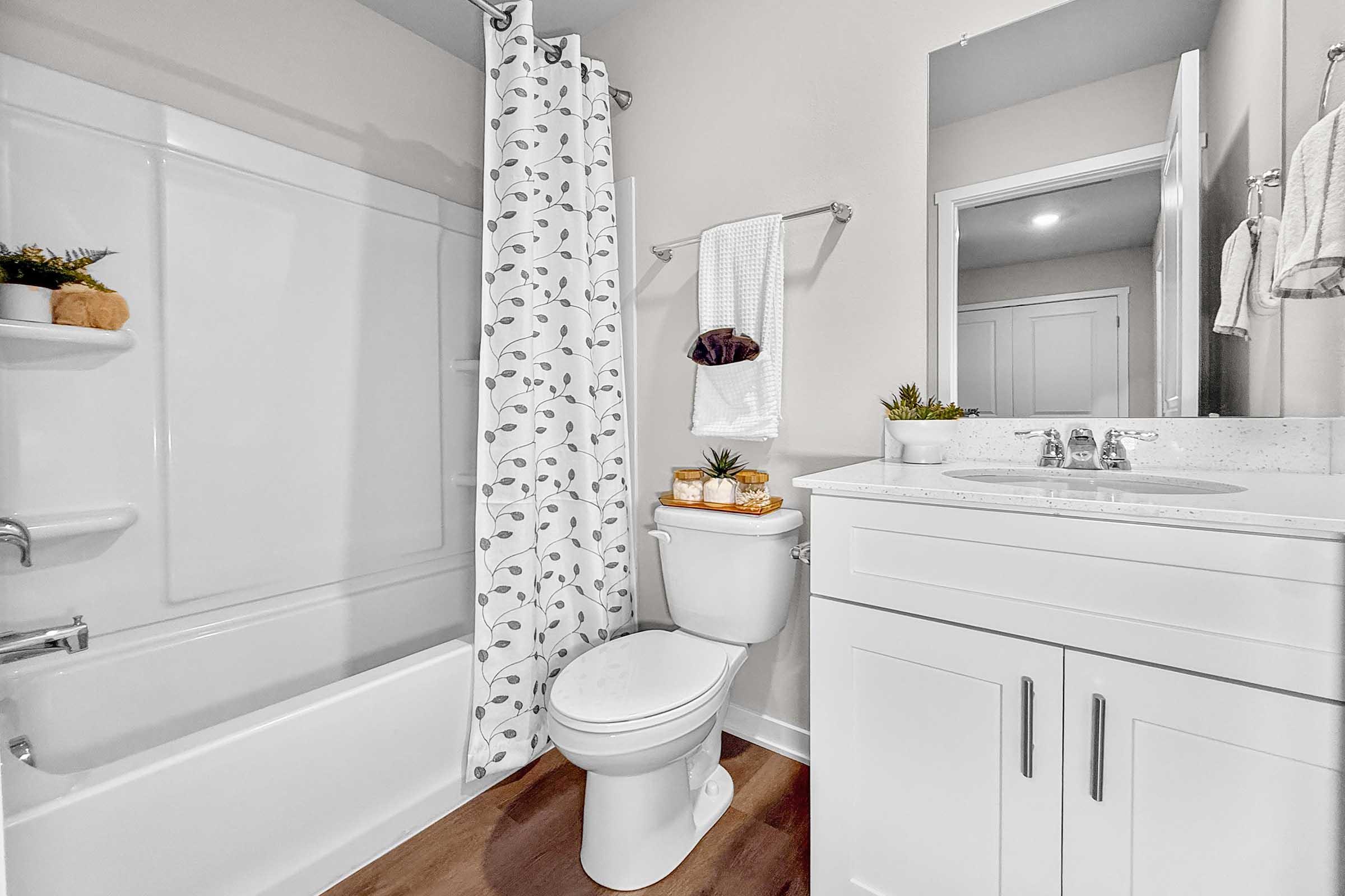 Full bathroom with tub and modern vanity in Painted Woods Villas townhome in Waukee, IA.