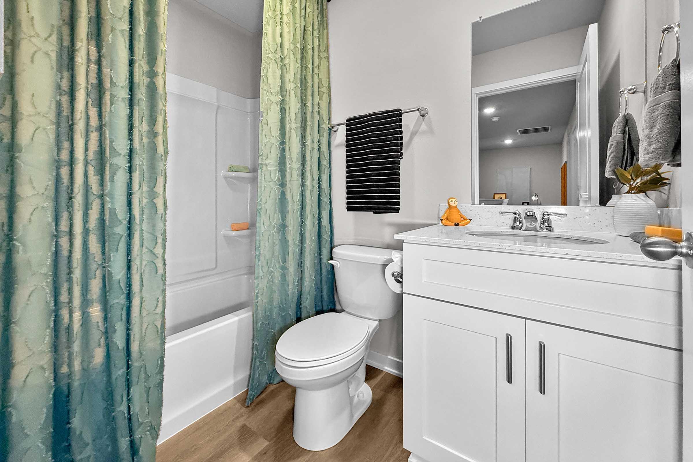 Full bathroom with modern vanity and shower/tub combo in new Waukee townhome at Painted Woods Villas.
