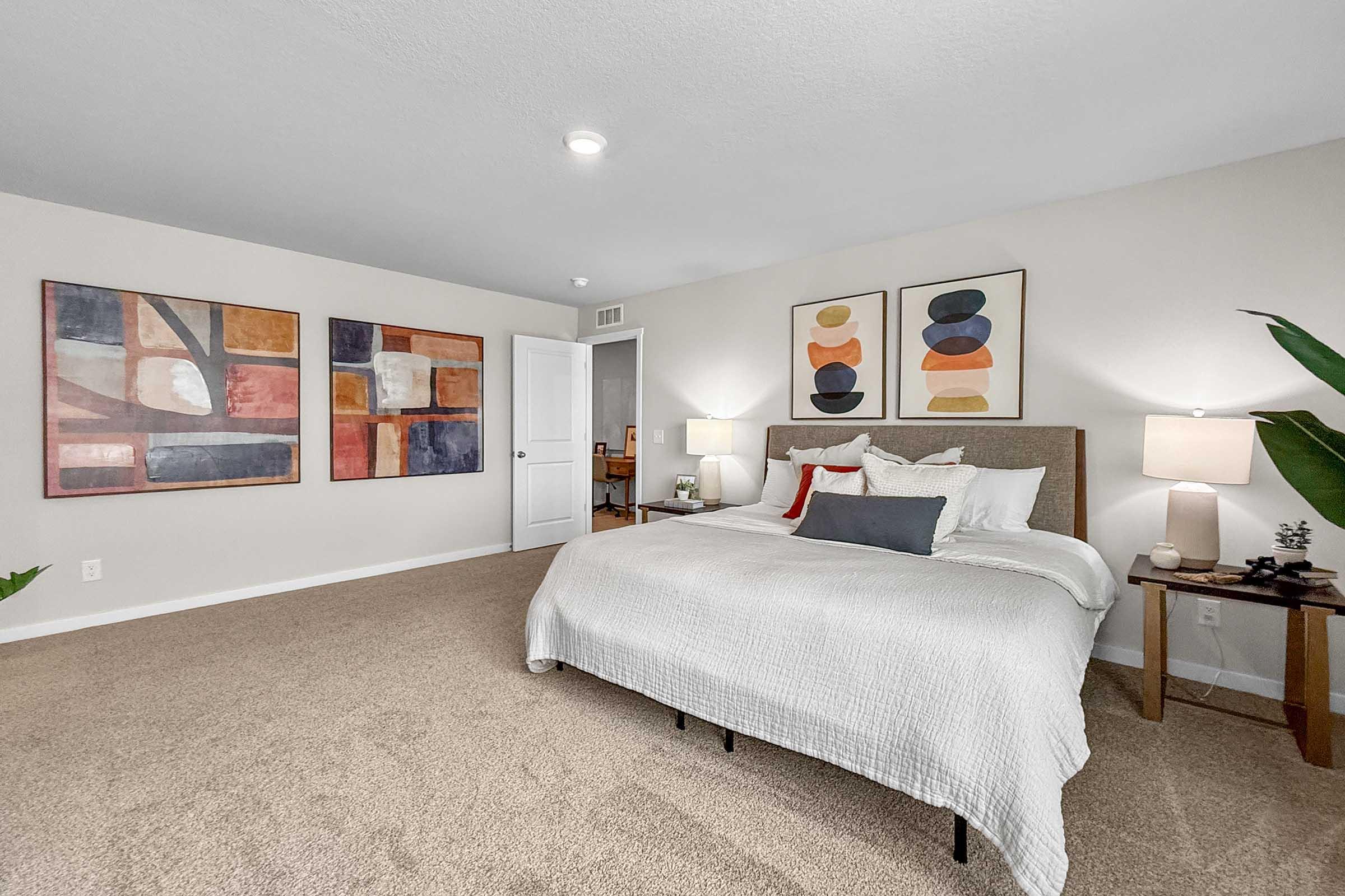 Spacious primary bedroom with plush carpet in new construction Waukee three-bedroom townhome.