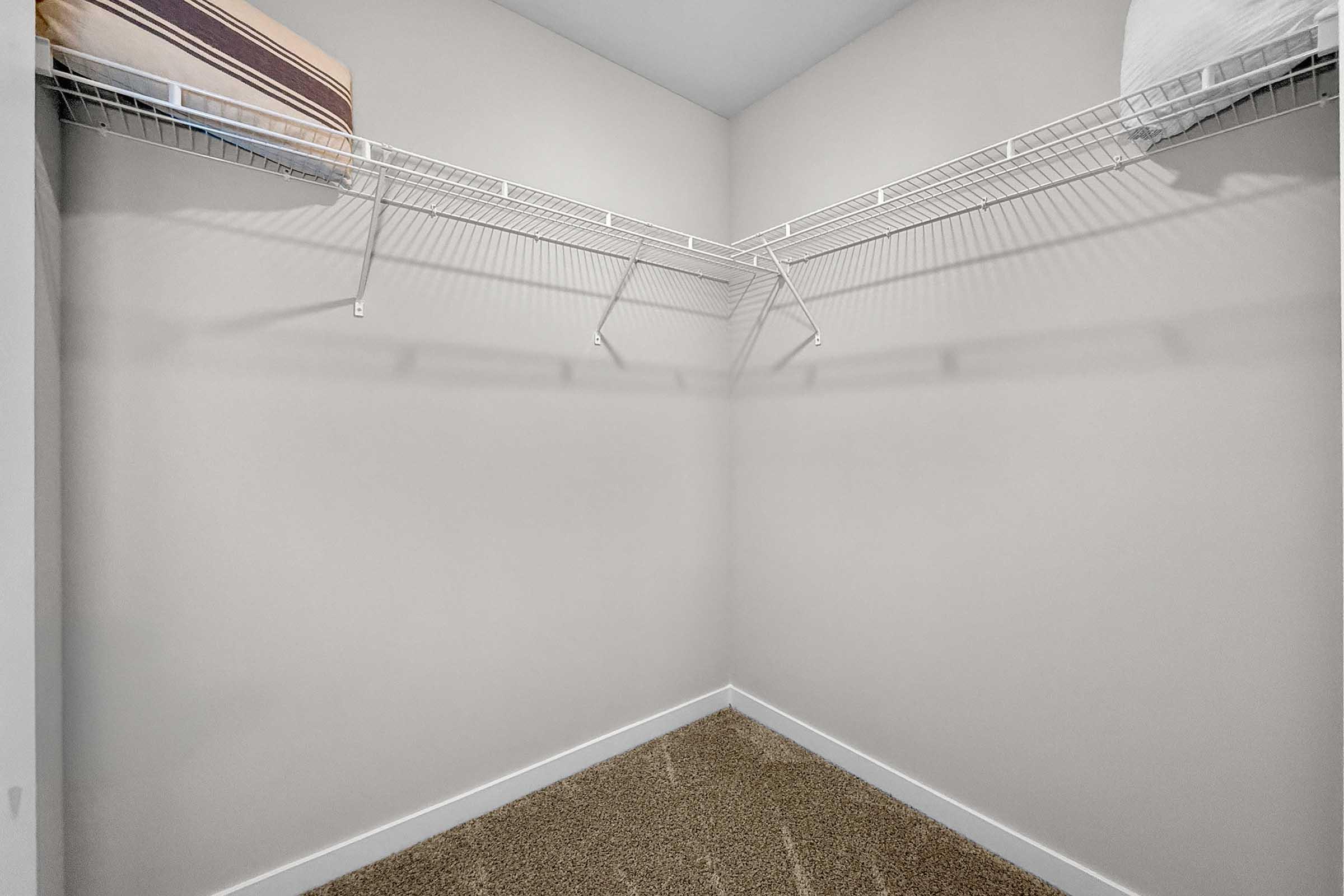 Walk-in closet with built-in shelving in Painted Woods Villas three-bedroom townhome.