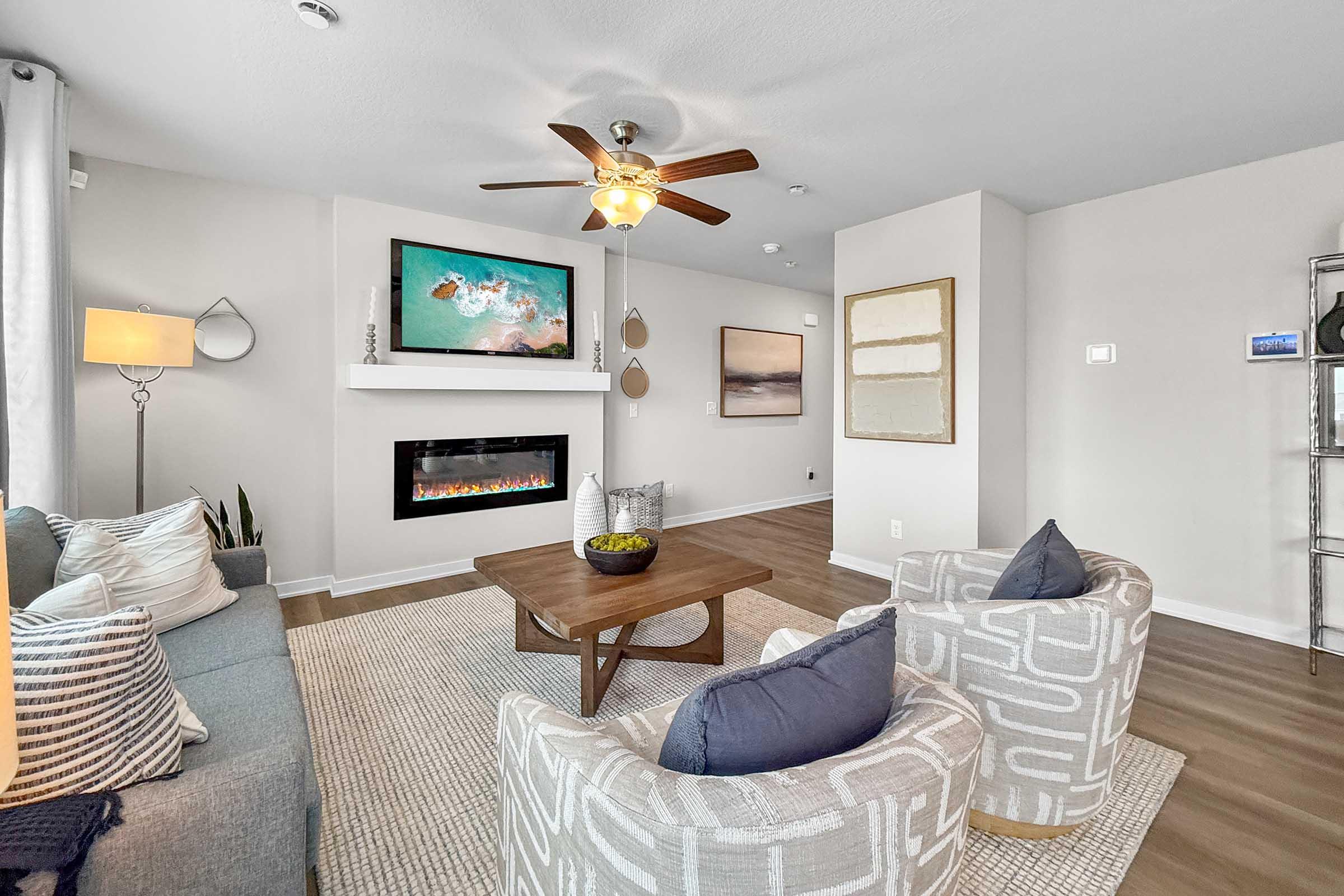 Cozy family room with modern fireplace and ceiling fan in Painted Woods Villas new construction townhome.