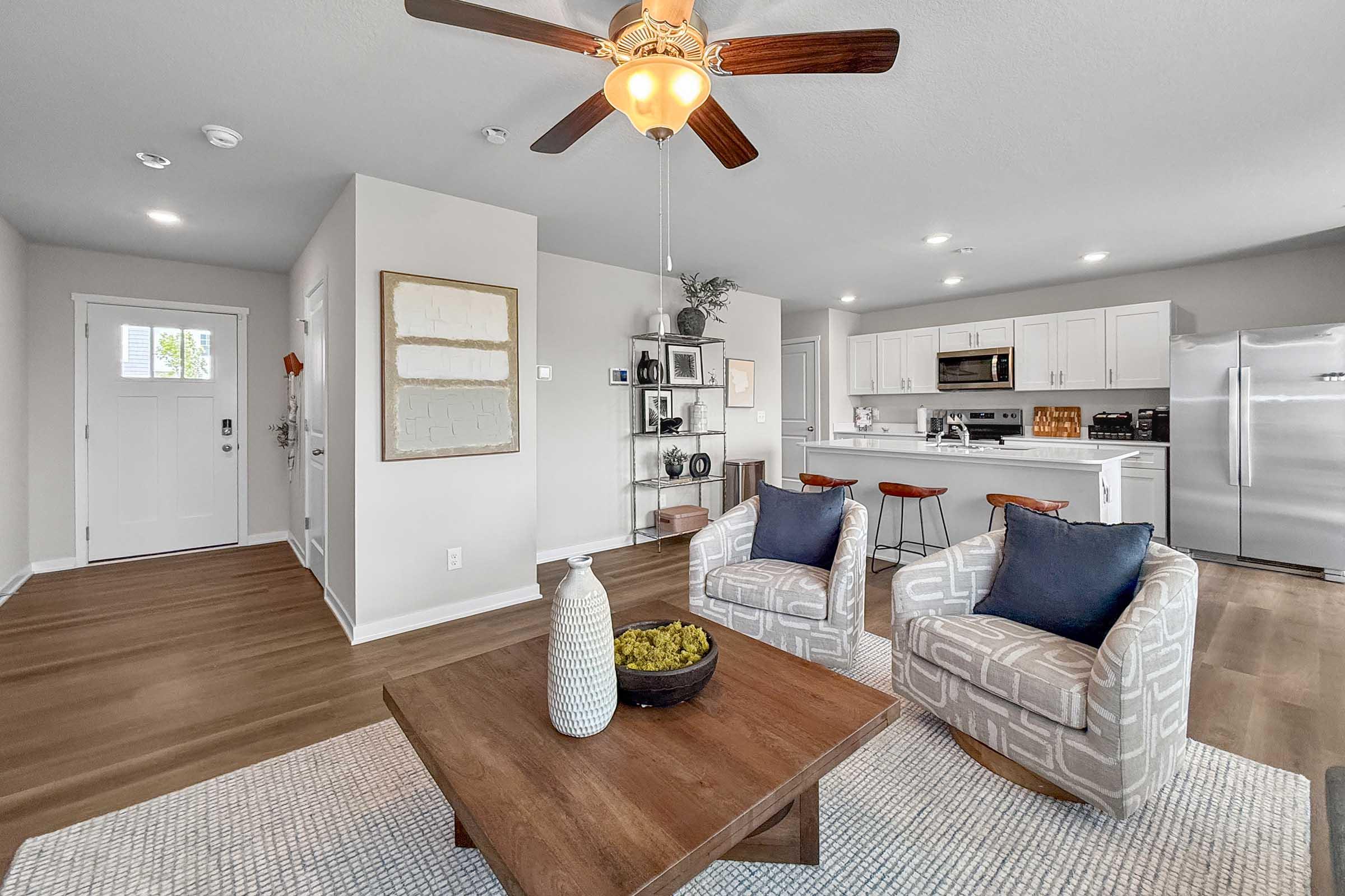 Open-concept living room and kitchen in new Waukee townhome at Painted Woods Villas with wood-style floors.