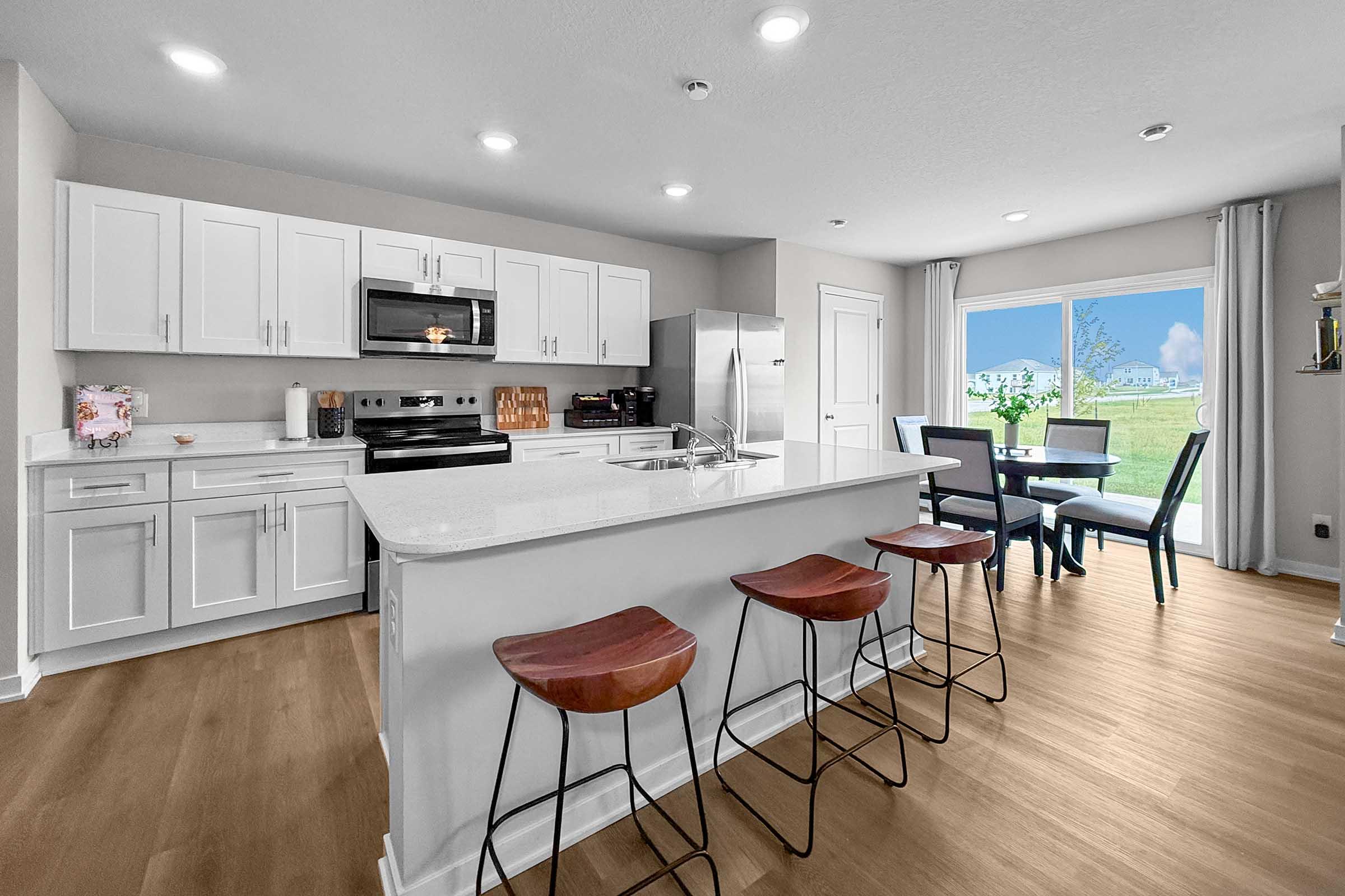 Spacious kitchen with quartz countertops and bar seating in Waukee townhome at Painted Woods Villas.