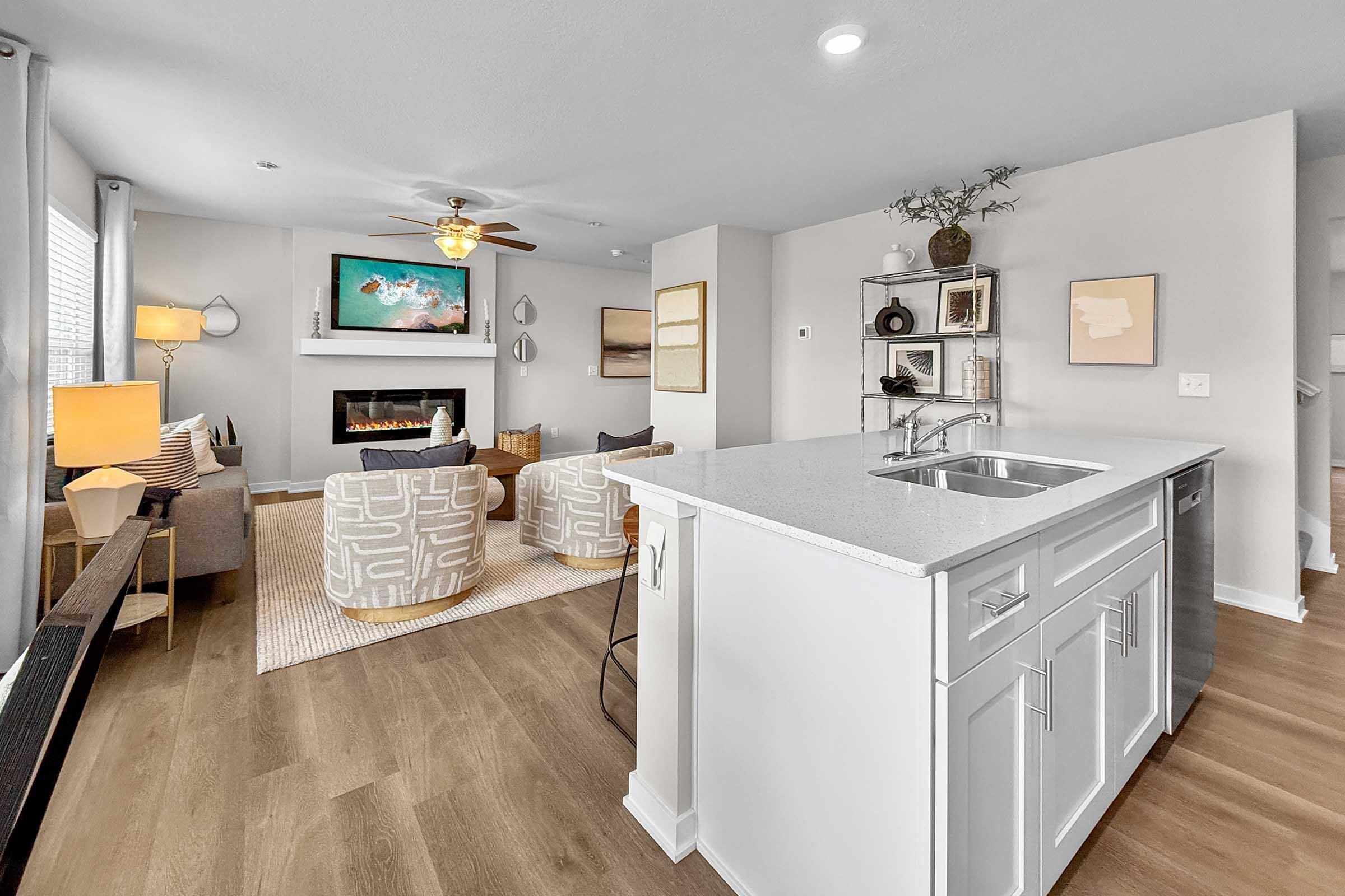Kitchen with quartz island and view into family room in Painted Woods Villas new three-bedroom townhome.