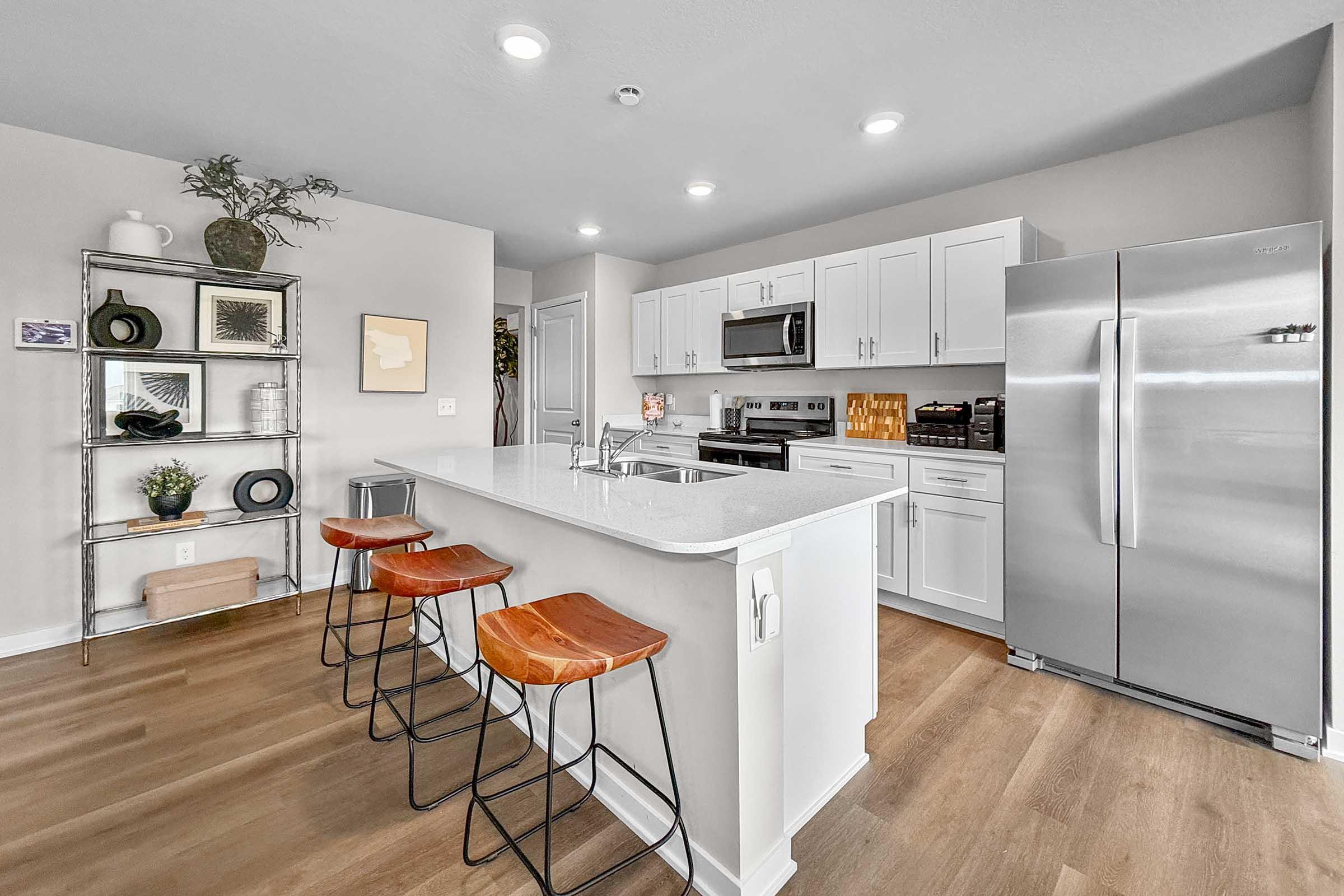 Contemporary kitchen with stainless steel appliances and breakfast bar seating in Painted Woods Villas.