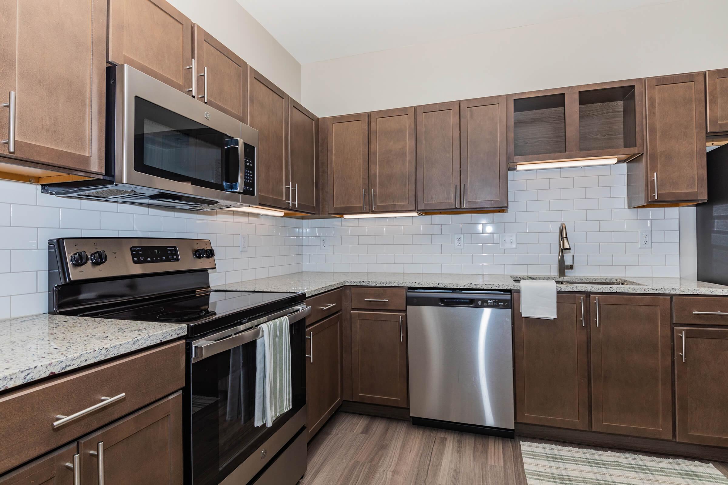 a modern kitchen with stainless steel appliances and wooden cabinets