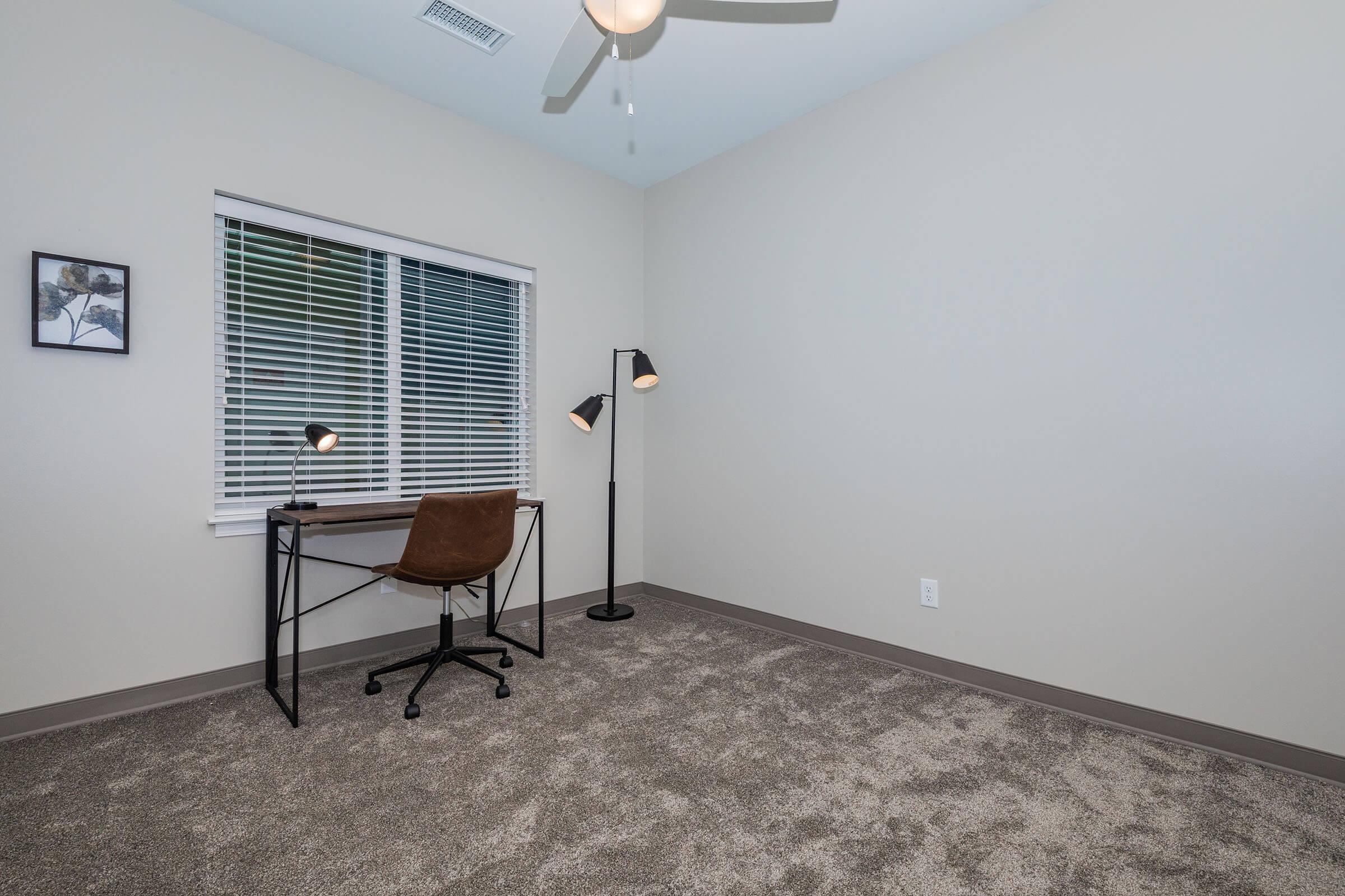 a bedroom with a bed and a chair in a room