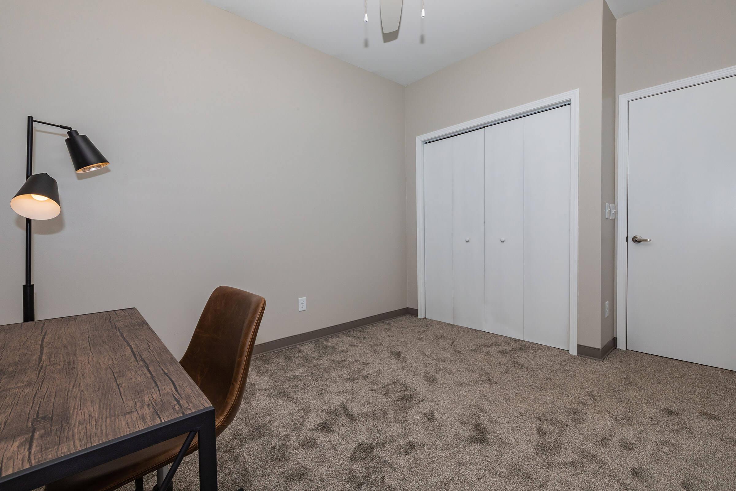 a bedroom with a bed and desk in a small room