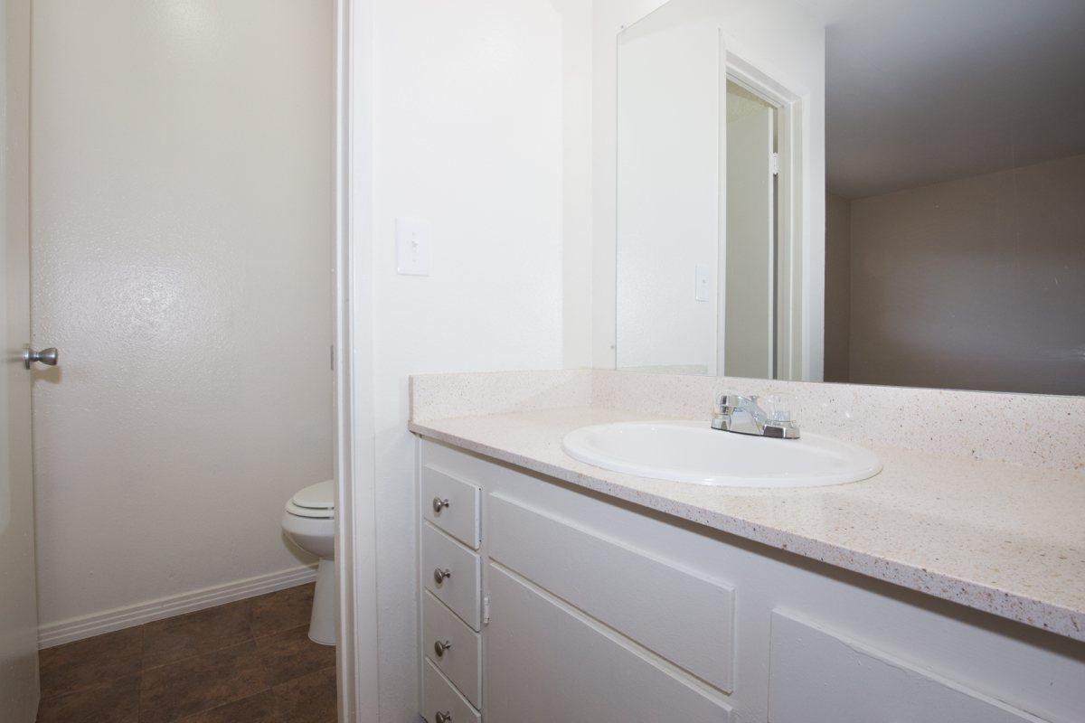 a white sink sitting under a mirror